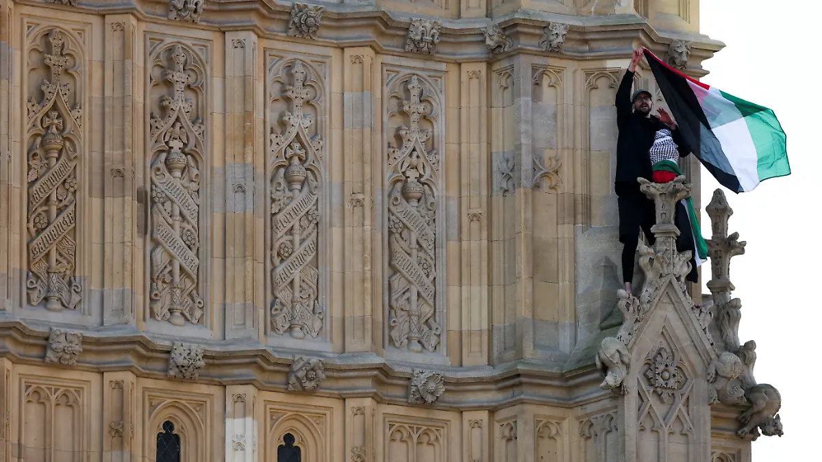 A man waves a Palestinian flag as he stands on the Elizabeth Tower, commonly known as Big Ben, next to Houses of Parliament, in London, Britain March 8, 2025.