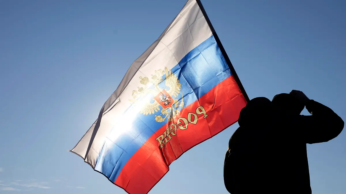 13.03.2022, Serbien, Belgrad: Ein Mann hält eine russische Fahne während einer Kundgebung zur Unterstützung Russlands. Außenministerin Baerbock hat Serbiens Präsident Vucic angesichts des russischen Angriffskriegs von Präsident Putin in der Ukraine aufgefordert, klar Farbe zu bekennen. Foto: Darko Vojinovic/AP/dpa +++ dpa-Bildfunk +++