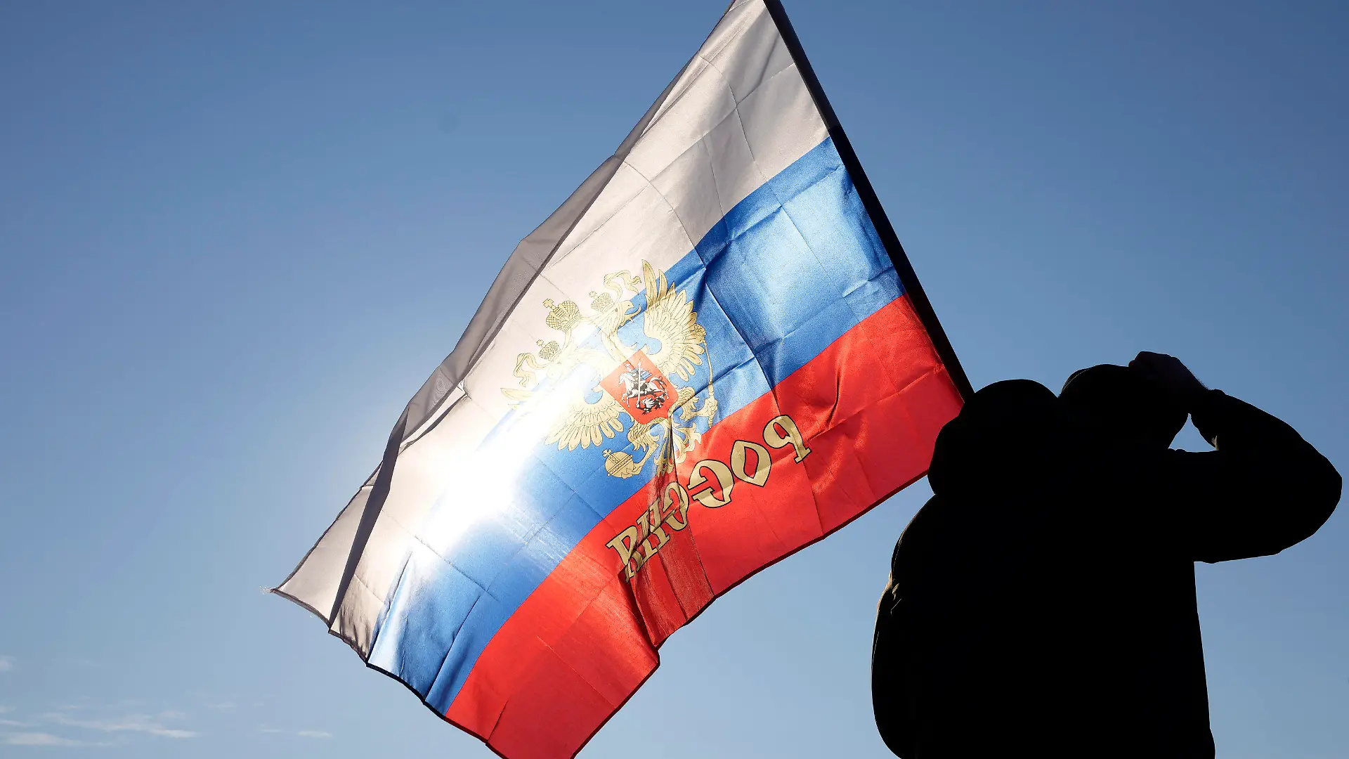 13.03.2022, Serbien, Belgrad: Ein Mann hält eine russische Fahne während einer Kundgebung zur Unterstützung Russlands. Außenministerin Baerbock hat Serbiens Präsident Vucic angesichts des russischen Angriffskriegs von Präsident Putin in der Ukraine aufgefordert, klar Farbe zu bekennen. Foto: Darko Vojinovic/AP/dpa +++ dpa-Bildfunk +++