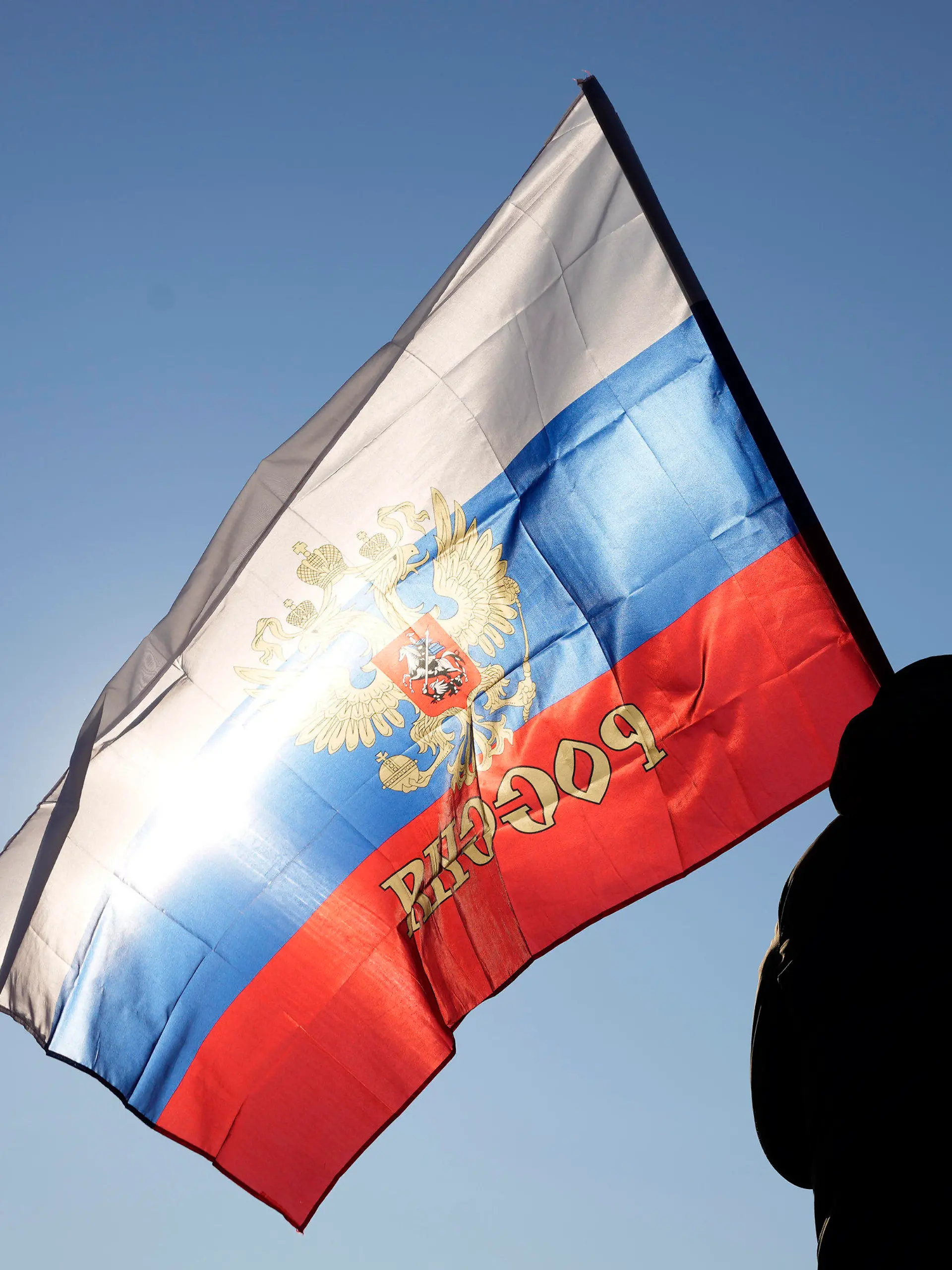 13.03.2022, Serbien, Belgrad: Ein Mann hält eine russische Fahne während einer Kundgebung zur Unterstützung Russlands. Außenministerin Baerbock hat Serbiens Präsident Vucic angesichts des russischen Angriffskriegs von Präsident Putin in der Ukraine aufgefordert, klar Farbe zu bekennen. Foto: Darko Vojinovic/AP/dpa +++ dpa-Bildfunk +++