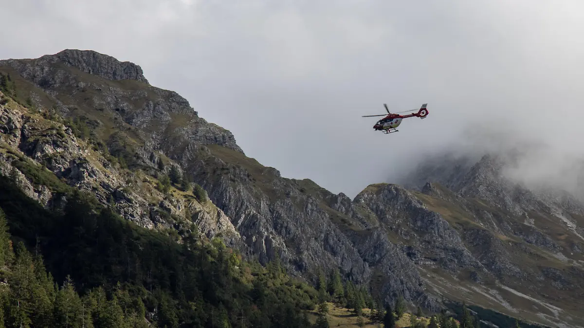 Der Rettungshubschrauber "RK2" ist in den Alpen bei Oberstdorf bei einem Bergunfall mit der Rettungswinde im Einsatz.
