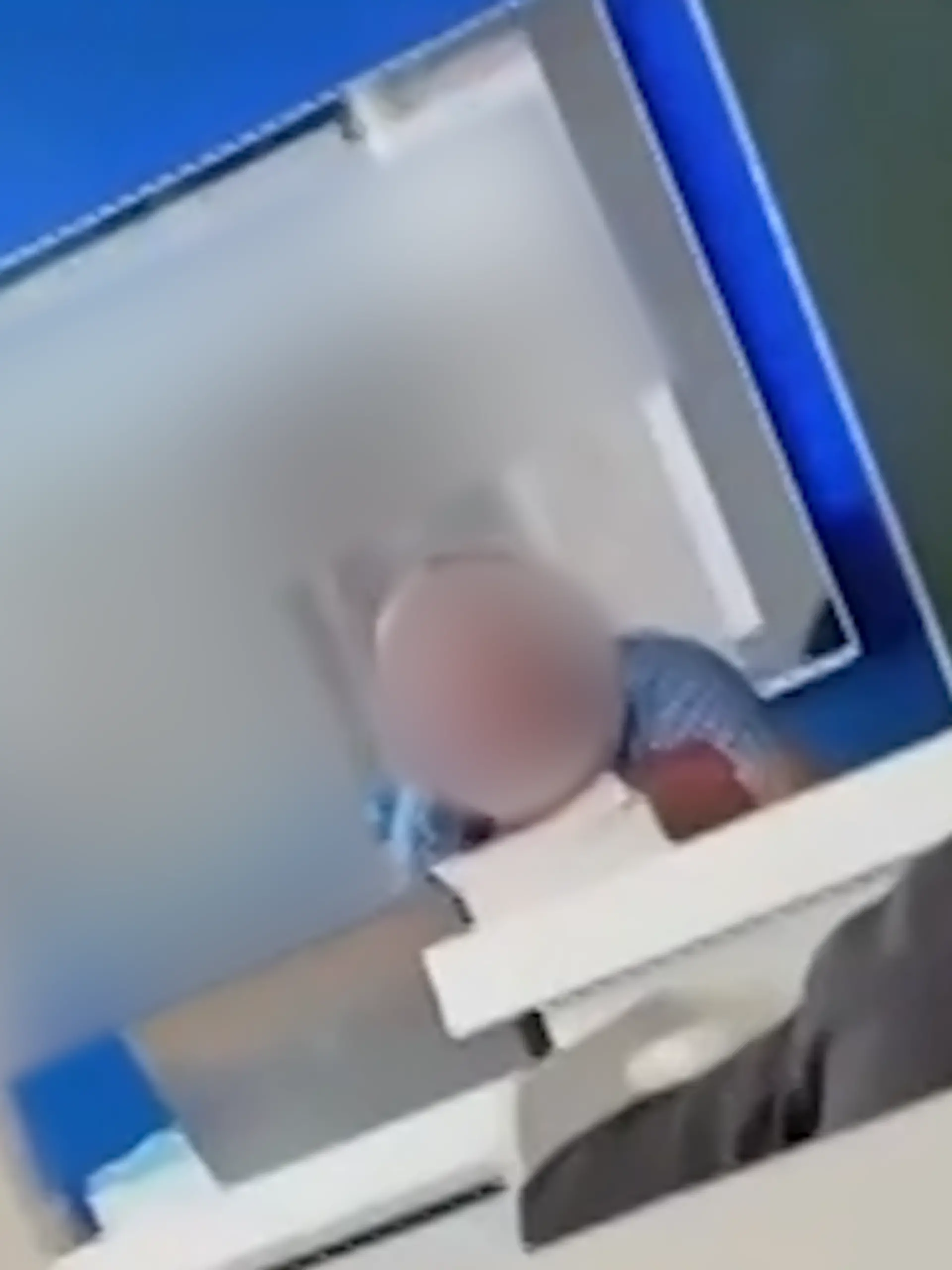 Ein Lehrer sitzt vor der Klasse mit dem Laptop, hinter ihm spielen Pornos auf der Leinwand ab.