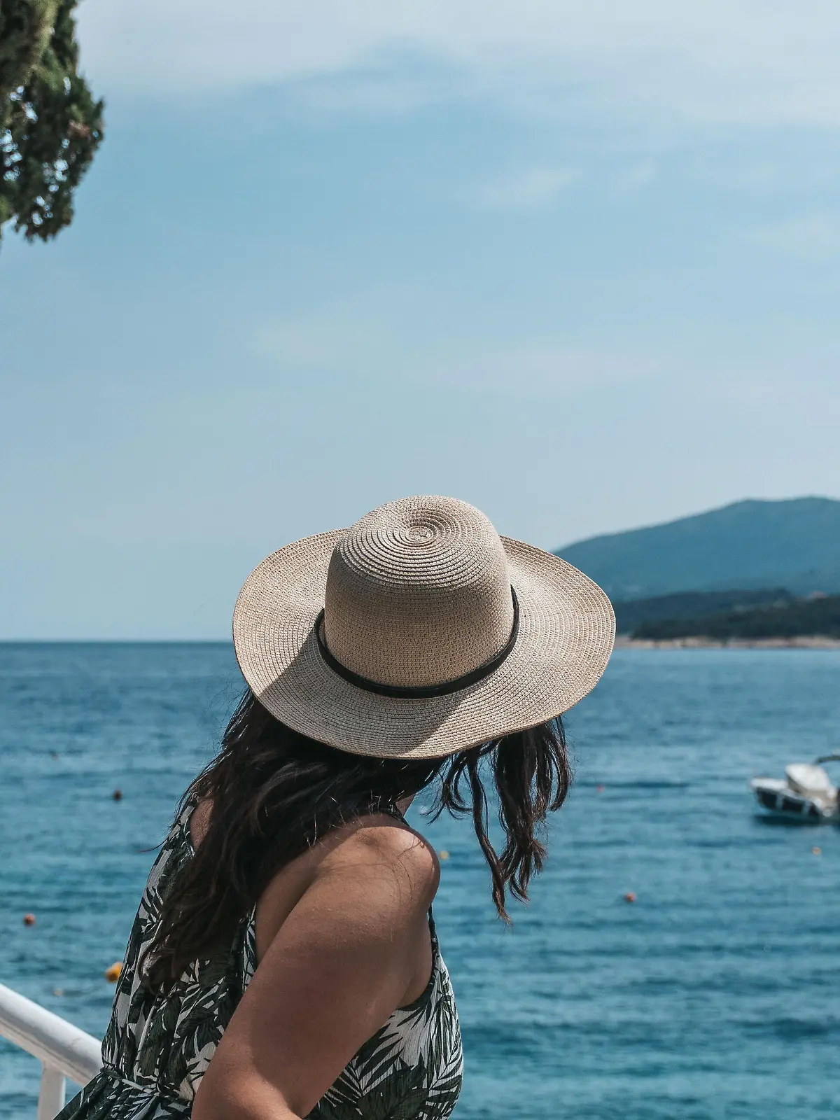 A woman leaning on a railing on the seashore in Rabac, Croatia