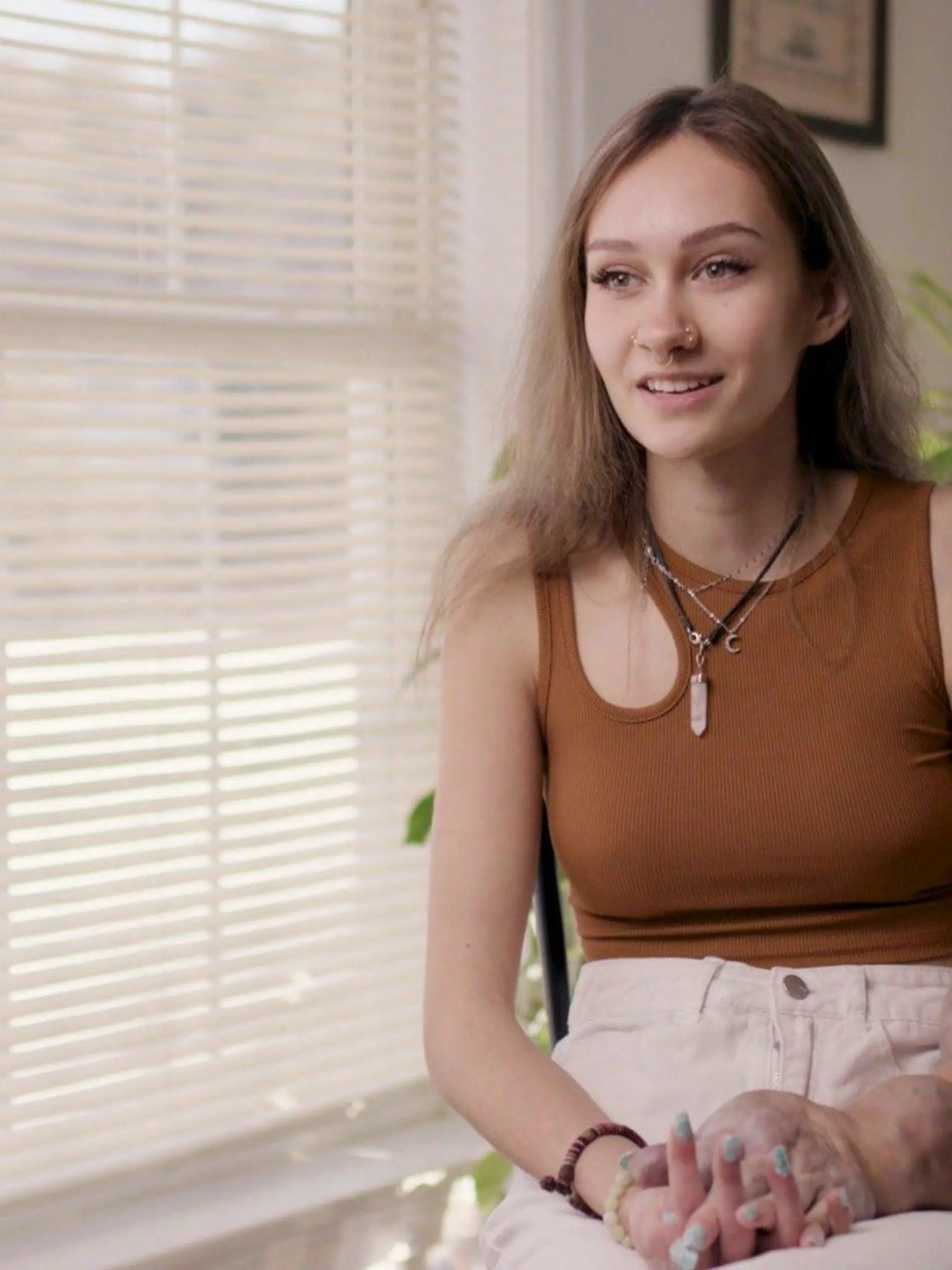 Olivia Klopchin (17) sitzt im Interview auf eine Stuhl. Ihre beiden Arme im direkten Vergleich sind gut zu erkennen.