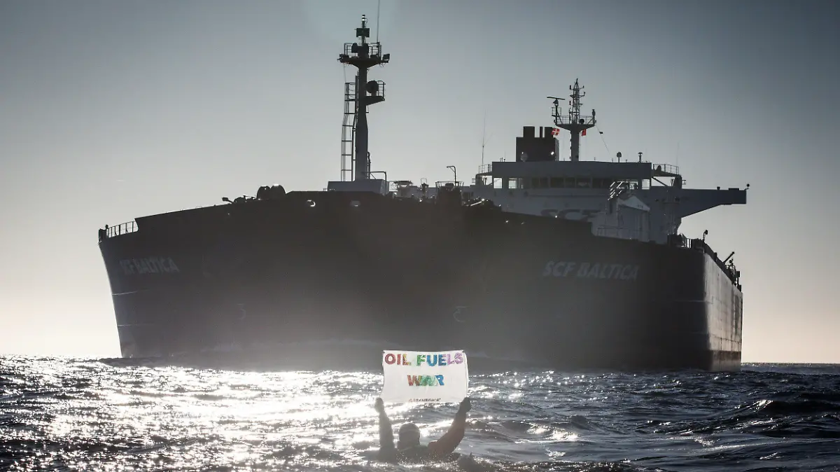 HANDOUT - 19.03.2022, ---, Ostsee: Auf Kayaks, kleinen Booten oder direkt im Wasser schwimmend haben Umweltaktivisten von Greenpeace gegen russische Öltanker in der Ostsee demonstriert. Auf Bildern vom Freitag und Samstag war zu sehen, wie Aktivisten mit Rauchsignalen und Bannern im Fahrwasser der großen Tanker darauf aufmerksam machten, dass weiterhin russisches Öl in europäische Länder gebracht wird. Die Teilnehmer des Protests stammen Greenpeace zufolge aus verschiedenen skandinavischen Ländern, den Niederlanden und Deutschland. Foto: Will Rose/Greenpeace NORDIC - Denmark, Fin/dpa - ACHTUNG: Nur zur redaktionellen Verwendung im Zusammenhang mit der aktuellen Berichterstattung und nur mit vollständiger Nennung des vorstehenden Credits +++ dpa-Bildfunk +++