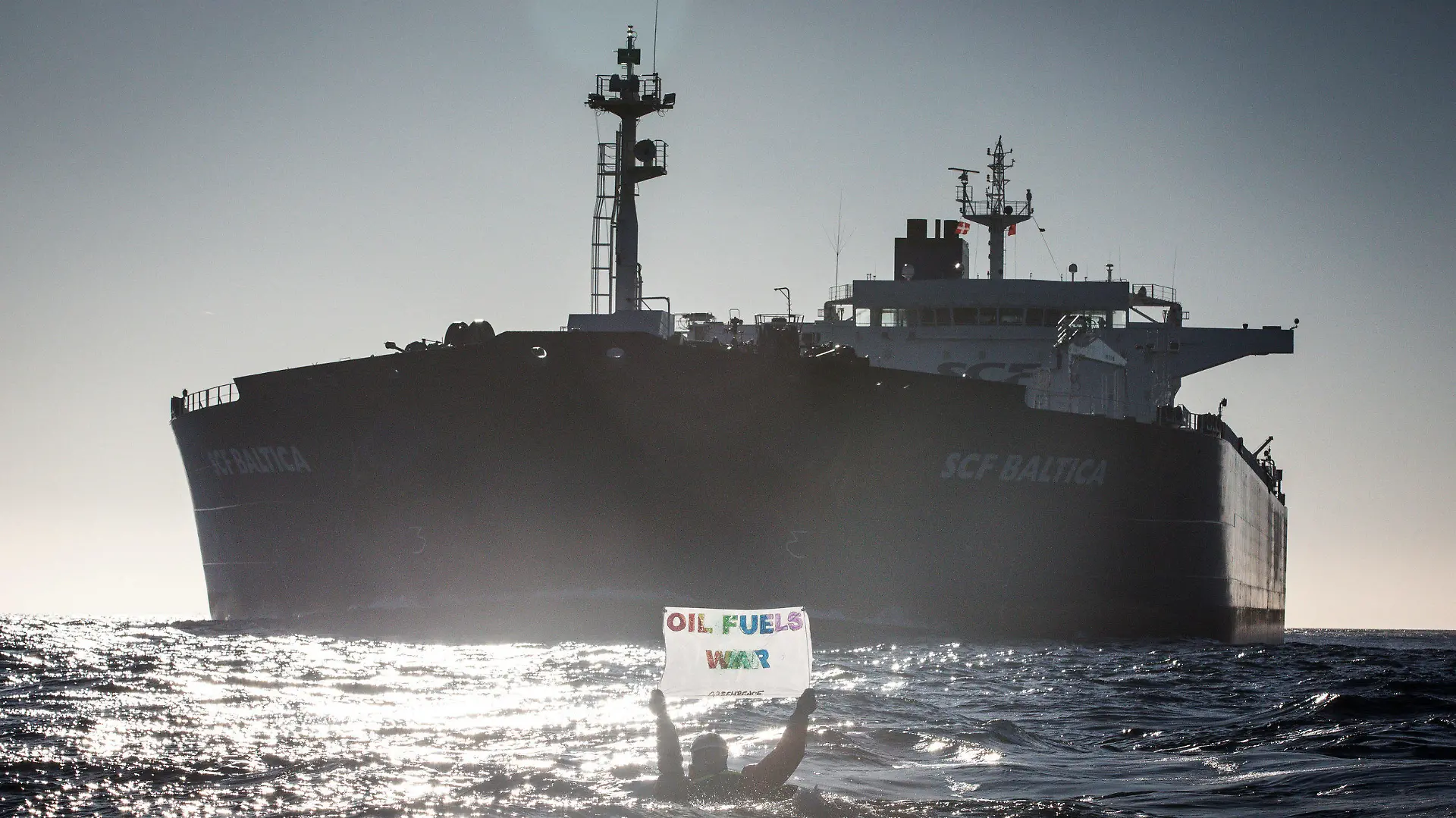 HANDOUT - 19.03.2022, ---, Ostsee: Auf Kayaks, kleinen Booten oder direkt im Wasser schwimmend haben Umweltaktivisten von Greenpeace gegen russische Öltanker in der Ostsee demonstriert. Auf Bildern vom Freitag und Samstag war zu sehen, wie Aktivisten mit Rauchsignalen und Bannern im Fahrwasser der großen Tanker darauf aufmerksam machten, dass weiterhin russisches Öl in europäische Länder gebracht wird. Die Teilnehmer des Protests stammen Greenpeace zufolge aus verschiedenen skandinavischen Ländern, den Niederlanden und Deutschland. Foto: Will Rose/Greenpeace NORDIC - Denmark, Fin/dpa - ACHTUNG: Nur zur redaktionellen Verwendung im Zusammenhang mit der aktuellen Berichterstattung und nur mit vollständiger Nennung des vorstehenden Credits +++ dpa-Bildfunk +++