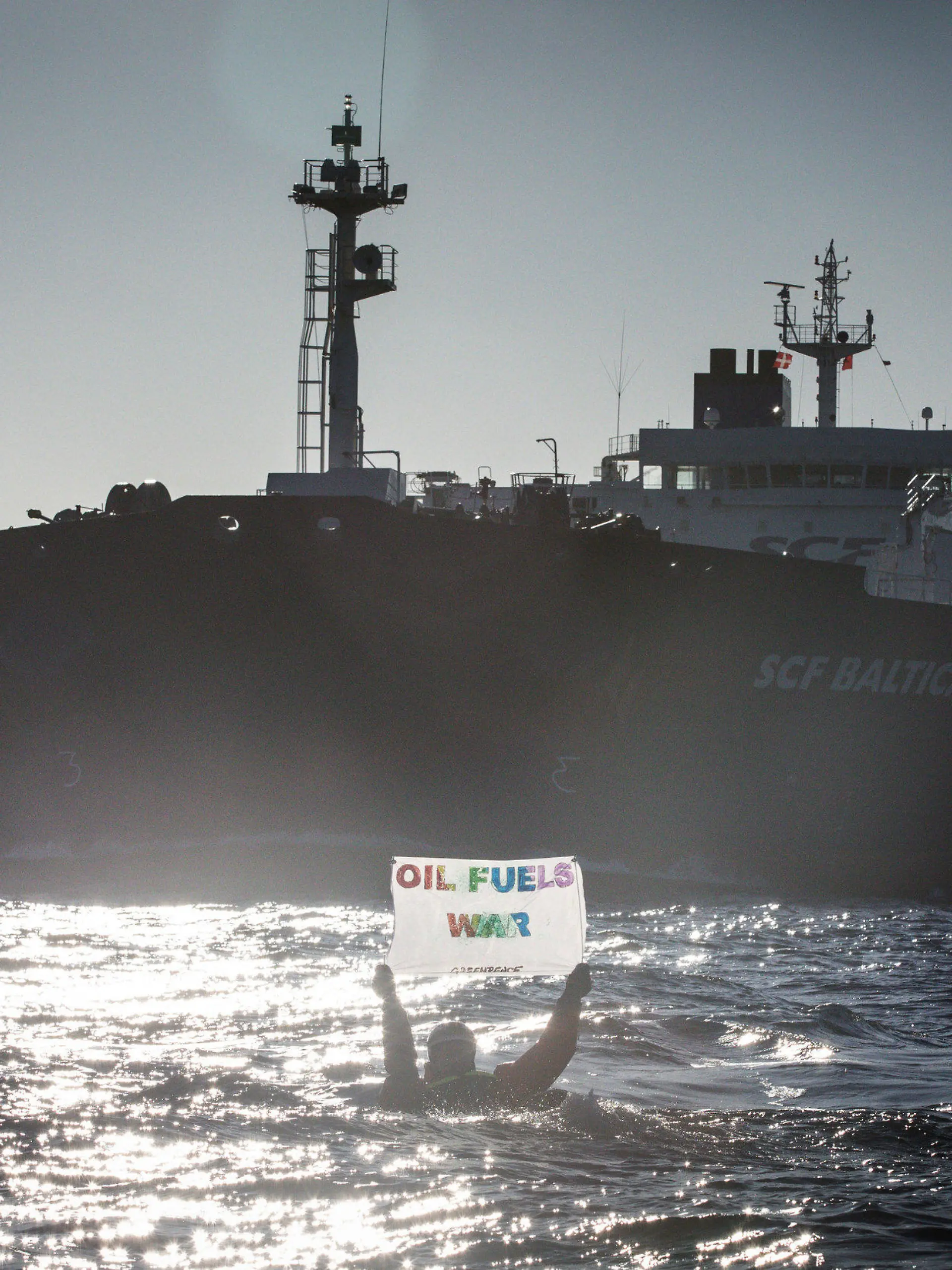 HANDOUT - 19.03.2022, ---, Ostsee: Auf Kayaks, kleinen Booten oder direkt im Wasser schwimmend haben Umweltaktivisten von Greenpeace gegen russische Öltanker in der Ostsee demonstriert. Auf Bildern vom Freitag und Samstag war zu sehen, wie Aktivisten mit Rauchsignalen und Bannern im Fahrwasser der großen Tanker darauf aufmerksam machten, dass weiterhin russisches Öl in europäische Länder gebracht wird. Die Teilnehmer des Protests stammen Greenpeace zufolge aus verschiedenen skandinavischen Ländern, den Niederlanden und Deutschland. Foto: Will Rose/Greenpeace NORDIC - Denmark, Fin/dpa - ACHTUNG: Nur zur redaktionellen Verwendung im Zusammenhang mit der aktuellen Berichterstattung und nur mit vollständiger Nennung des vorstehenden Credits +++ dpa-Bildfunk +++