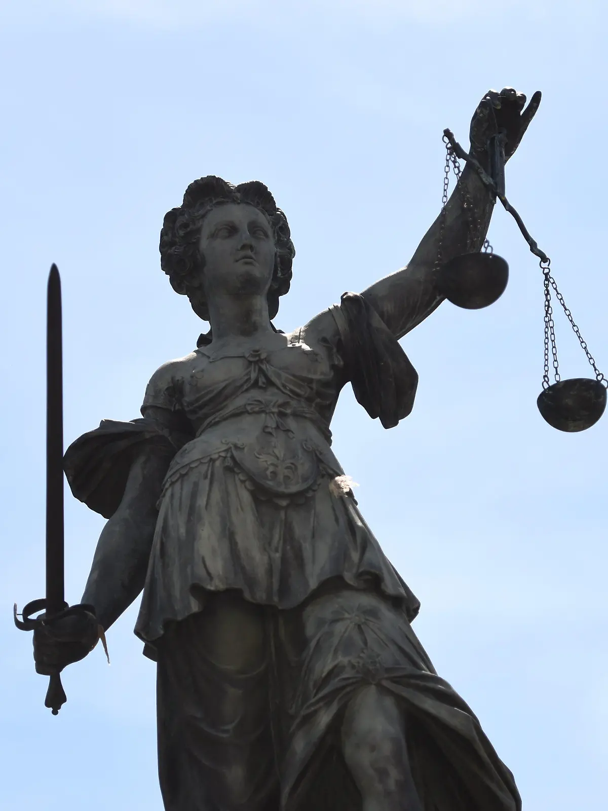 ARCHIV - Eine Bronzestatue der römischen Göttin der Gerechtigkeit, Justitia, steht am 17.06.2015 mit einer Waage und einem Richtschwert in der Hand auf dem Gerechtigkeitsbrunnen auf dem Römerberg in Frankfurt am Main (Hessen). Foto: Arne Dedert/dpa (zu dpa: "Häftlinge kommen wegen Überlastung der Gerichte frei" vom 22.08.2015) +++(c) dpa - Bildfunk+++