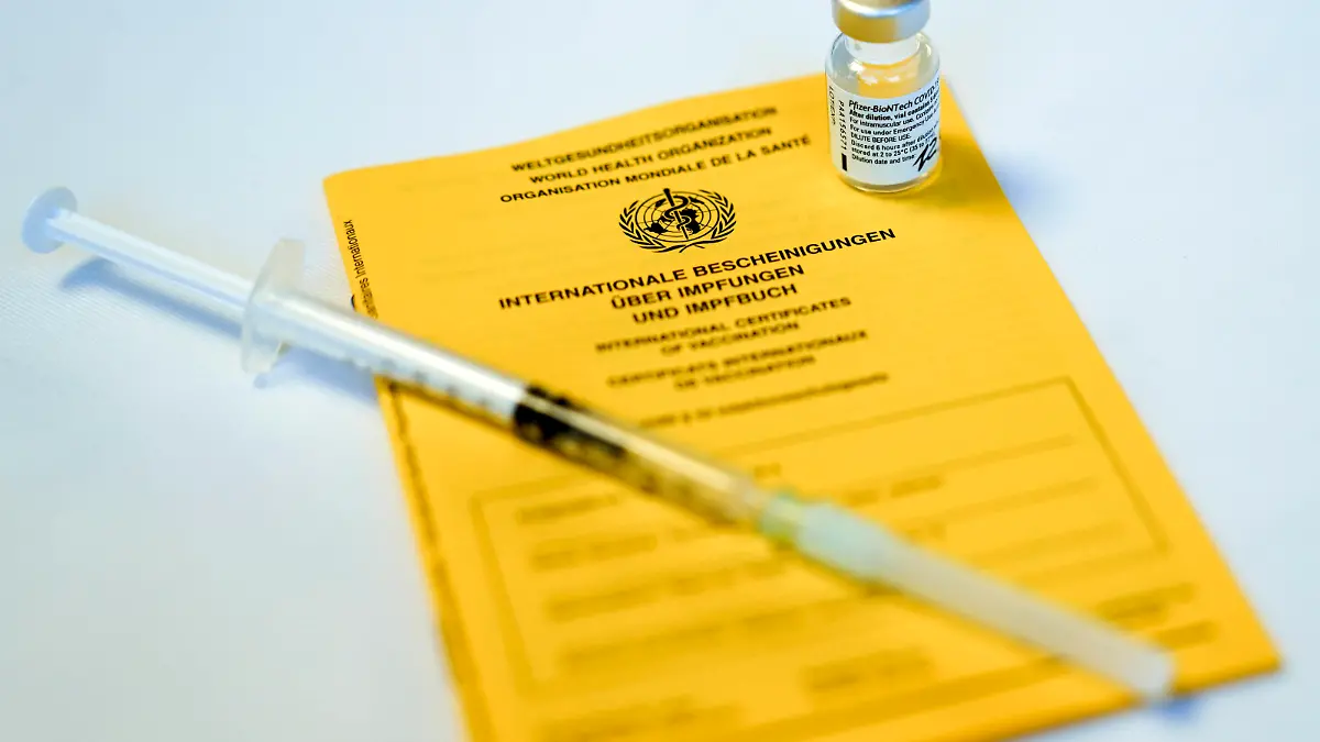 Impfstart in Koeln erste Bewohner von Pflegeheimen werden geimpft Symbolbild, Symbolfoto Impfpass mit einer Ampulle von Biontech Pfizer Impfstoff und Spritze wahrend der ersten Impfung in Pflegeheimen Koeln Nordrhein-Westfalen Deutschland *** Vaccination start in Cologne first residents of nursing homes are vaccinated symbol picture, symbol photo vaccination passport with an ampoule of Biontech Pfizer vaccine and syringe during the first vaccination in nursing homes Cologne North Rhine Westphalia Germany