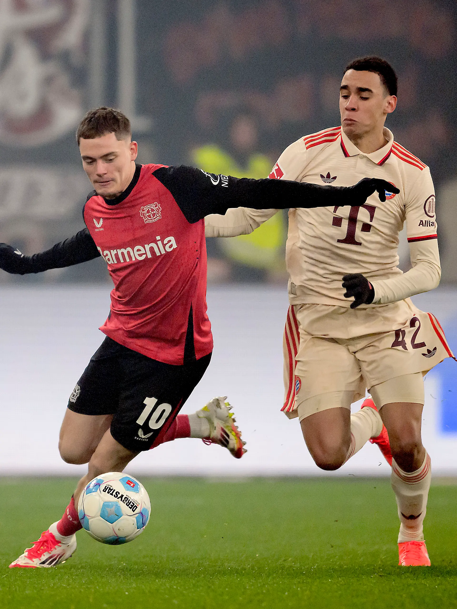 Florian Wirtz (l.)  von Bayer Leverkusen im Zweikampf mit Jamal Musiala von Bayern München
