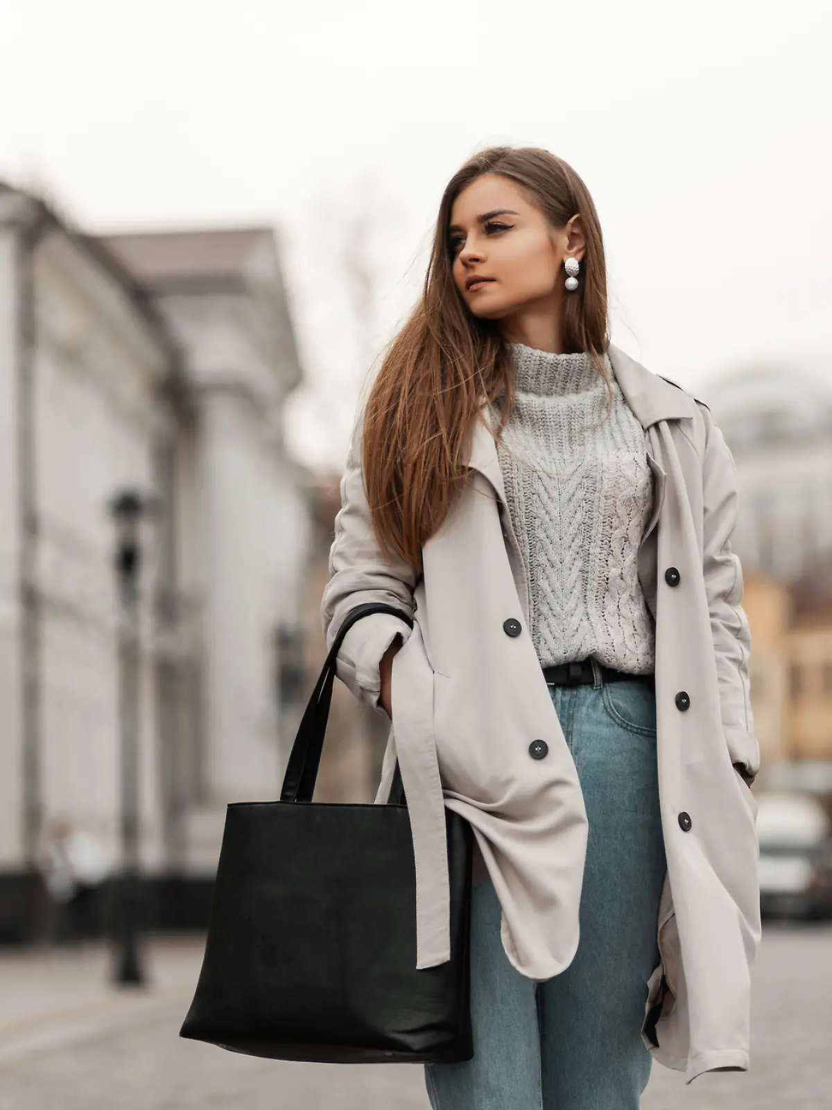 Junge Frau mit Trenchcoat und Pullover. 