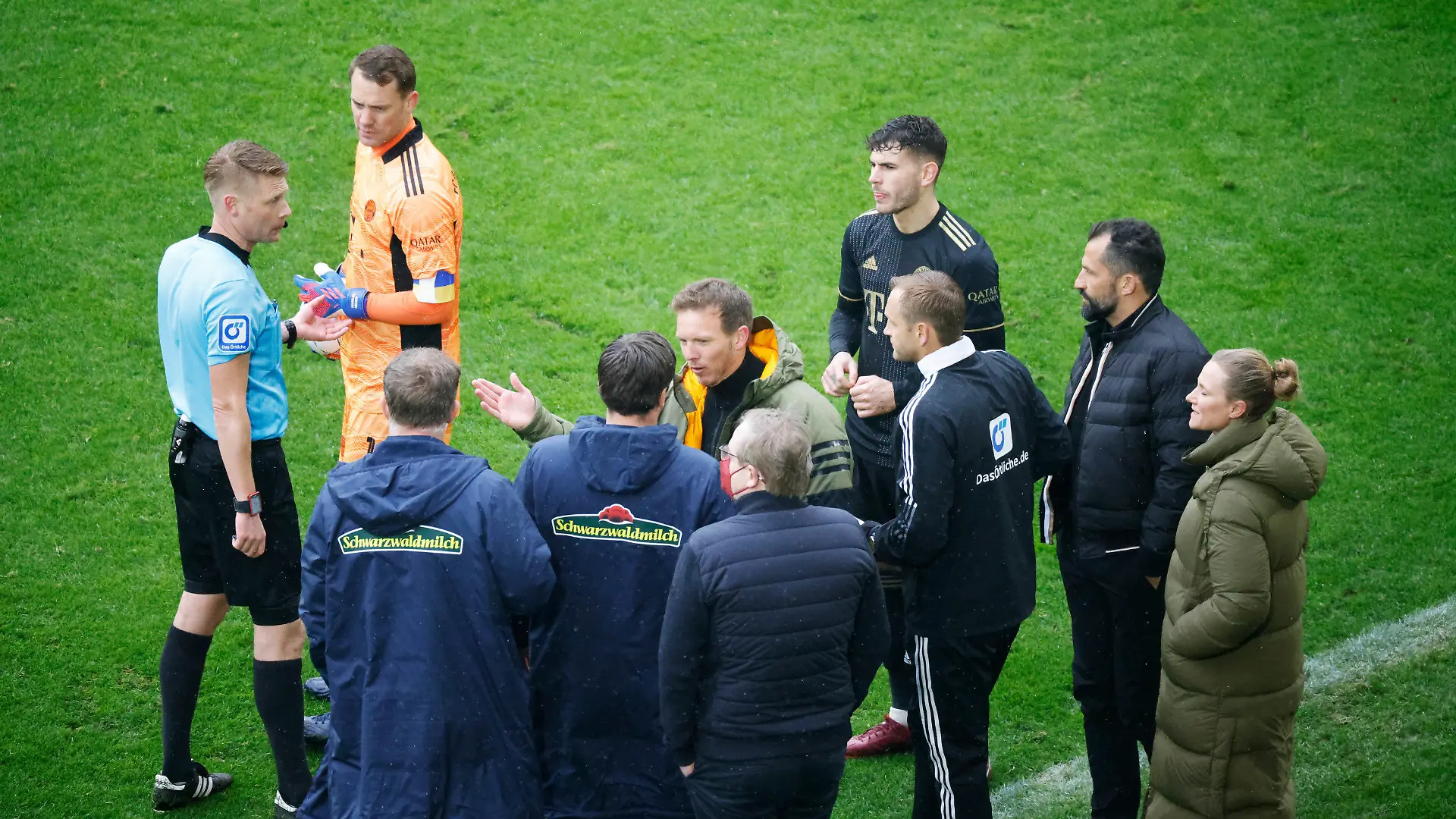 02.04.2022, Baden-Württemberg, Freiburg im Breisgau: Fußball: Bundesliga, SC Freiburg - Bayern München, 28. Spieltag, Europa-Park Stadion: Schiedsrichter Christian Dingert (l in blau) bespricht mit dem vierten Offiziellen sowie Spielern und Verantwortlichen des FC Bayern München sowie des SC Freiburg das Vorgehen. Der FC Bayern stand für rund 20 Sekunden mit einem Spieler zu viel auf dem Spielfeld. (zu dpa «Nach Bayern-Wechselfehler: Redebedarf bei DFB-Schiedsrichtern ») Foto: Philipp von Ditfurth/dpa - WICHTIGER HINWEIS: Gemäß den Vorgaben der DFL Deutsche Fußball Liga bzw. des DFB Deutscher Fußball-Bund ist es untersagt, in dem Stadion und/oder vom Spiel angefertigte Fotoaufnahmen in Form von Sequenzbildern und/oder videoähnlichen Fotostrecken zu verwerten bzw. verwerten zu lassen. +++ dpa-Bildfunk +++
