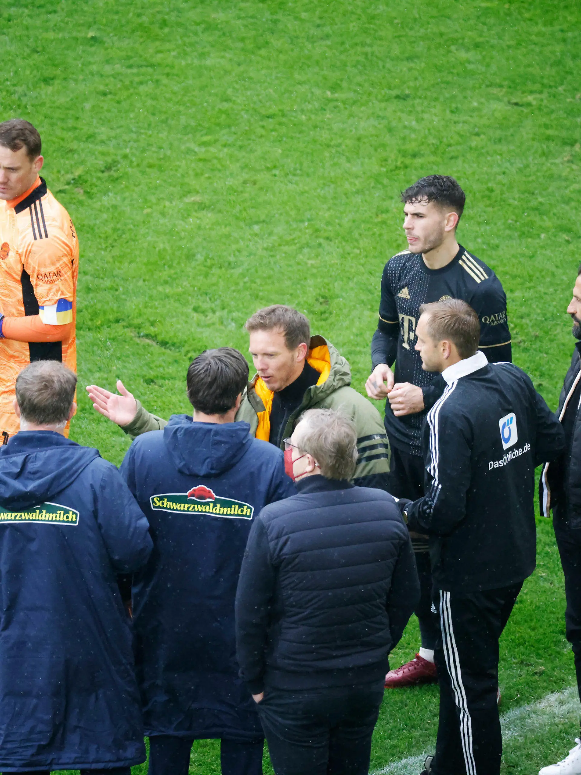 02.04.2022, Baden-Württemberg, Freiburg im Breisgau: Fußball: Bundesliga, SC Freiburg - Bayern München, 28. Spieltag, Europa-Park Stadion: Schiedsrichter Christian Dingert (l in blau) bespricht mit dem vierten Offiziellen sowie Spielern und Verantwortlichen des FC Bayern München sowie des SC Freiburg das Vorgehen. Der FC Bayern stand für rund 20 Sekunden mit einem Spieler zu viel auf dem Spielfeld. (zu dpa «Nach Bayern-Wechselfehler: Redebedarf bei DFB-Schiedsrichtern ») Foto: Philipp von Ditfurth/dpa - WICHTIGER HINWEIS: Gemäß den Vorgaben der DFL Deutsche Fußball Liga bzw. des DFB Deutscher Fußball-Bund ist es untersagt, in dem Stadion und/oder vom Spiel angefertigte Fotoaufnahmen in Form von Sequenzbildern und/oder videoähnlichen Fotostrecken zu verwerten bzw. verwerten zu lassen. +++ dpa-Bildfunk +++