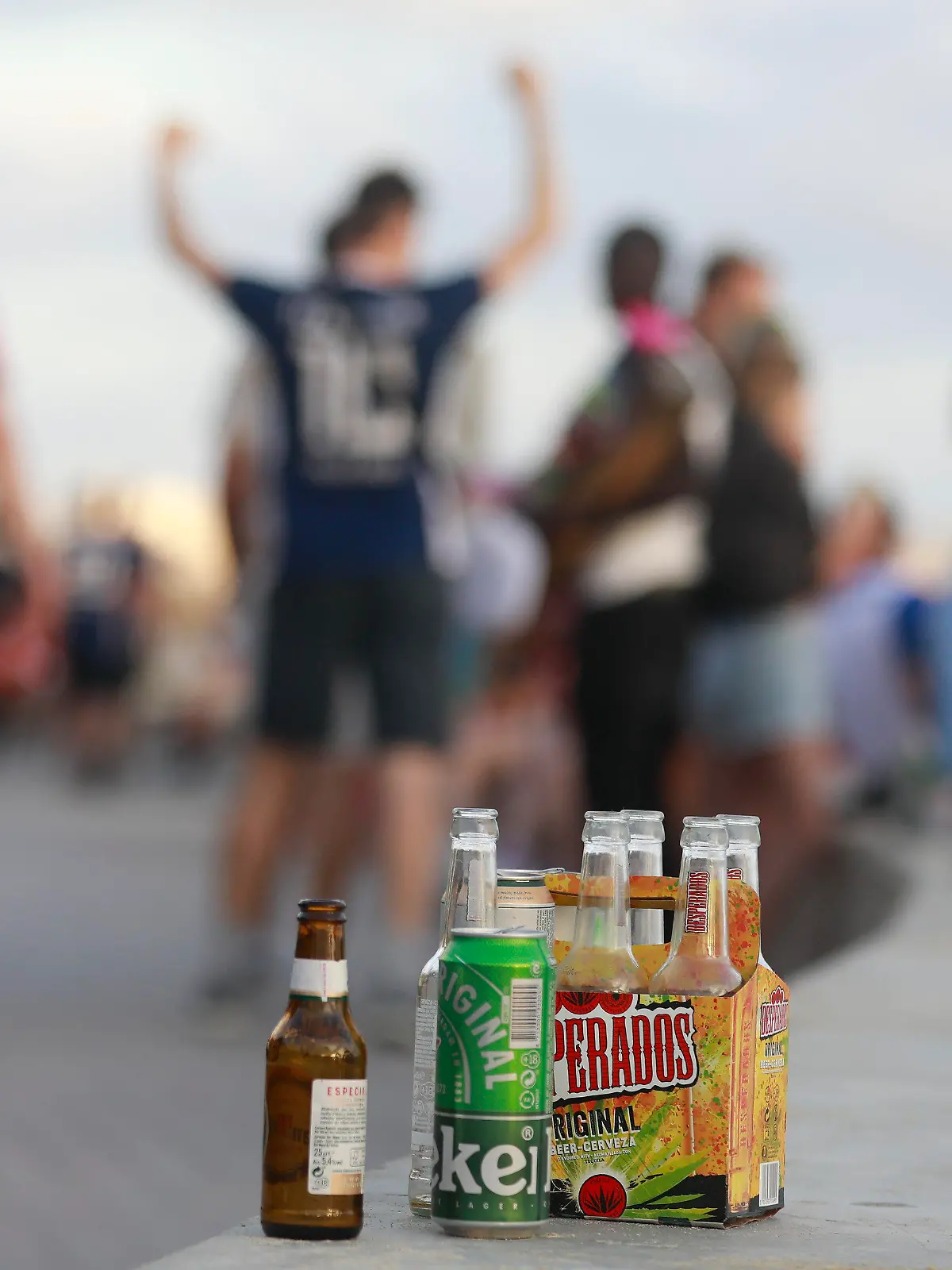 PRODUKTION - 09.06.2023, Spanien, Palma: Menschen haben sich am Abend an der Promenade am Strand von Arenal versammelt. Auf einer Balustrade stehen mehrere leere Flachen alkoholischer Getränke. Unternehmer schlagen Alarm, Nachbarn haben Angst. Am Ballermann sorgen die Partyurlauber dieses Jahr bereits lange vor Start der Hauptsaison für Ärger. (zu dpa "Sauftourismus nicht zu bremsen - Angst vor dem Sommer auf Mallorca") Foto: Clara Margais/dpa +++ dpa-Bildfunk +++