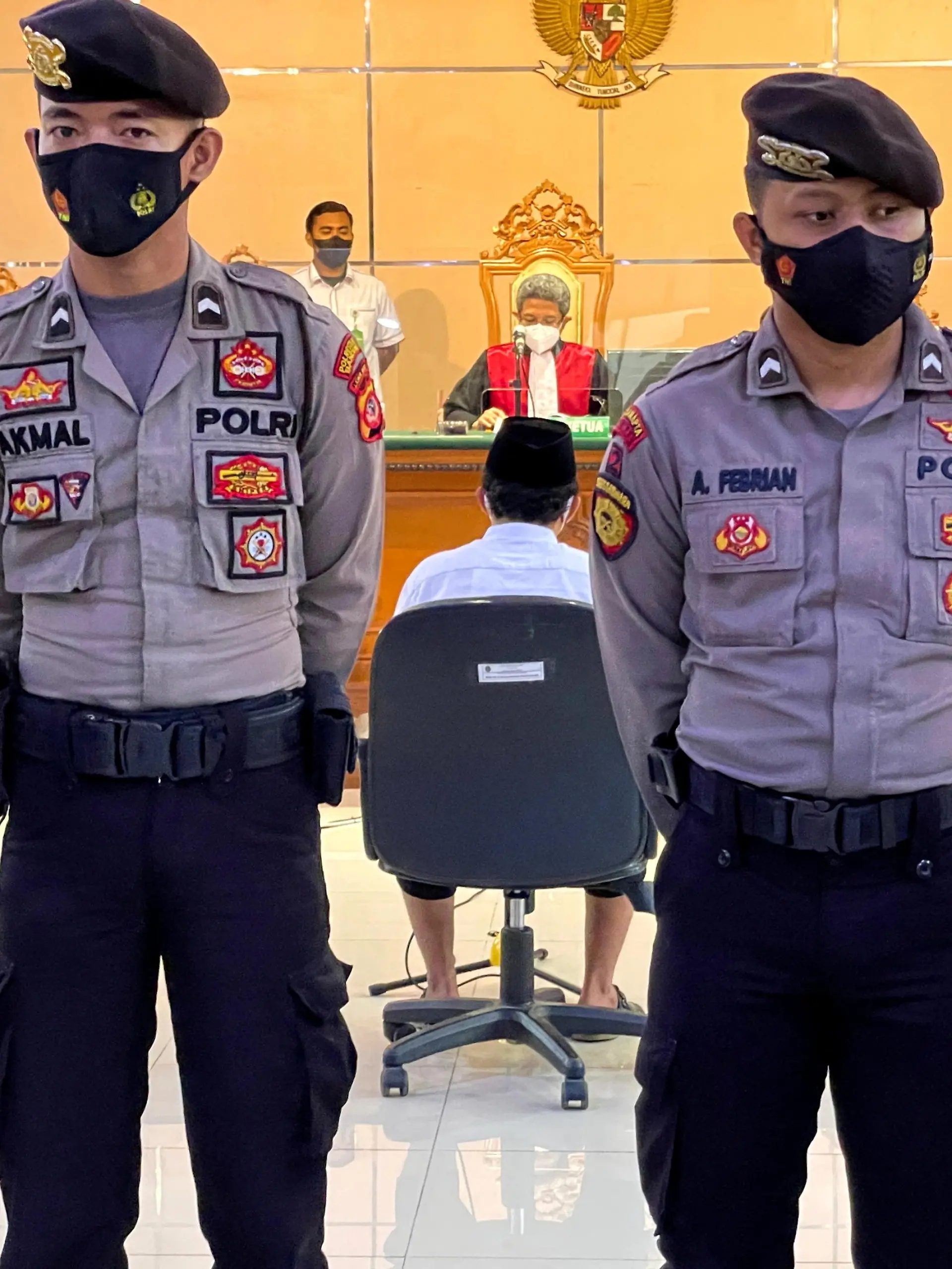 FILE PHOTO: Police officers stand guard during the verdict trial against Herry Wirawan (36), a former teacher and founder of an Islamic boarding school, who is accused of raping 13 school girls between 2016 and 2021, at the district court in Bandung, West Java province, Indonesia February 15, 2022. REUTERS/Heru Asprihanto/File Photo