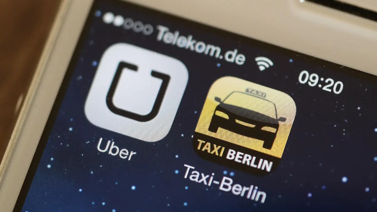 ARCHIV - Die Handy-Apps «Uber» und «Taxi Berlin» sind am 11.06.2014 auf einem Smartphone in Berlin zu sehen. Der umstrittene Fahrdienst-Vermittler Uber darf seine Leistungen in Deutschland vorerst bundesweit nicht mehr anbieten. Das Landgericht Frankfurt/Main hat in einem Eilverfahren eine entsprechende Einstweilige Verfügung erlassen. Foto: Jörg Carstensen/dpa (zu dpa 0036 vom 02.09.2014) +++(c) dpa - Bildfunk+++