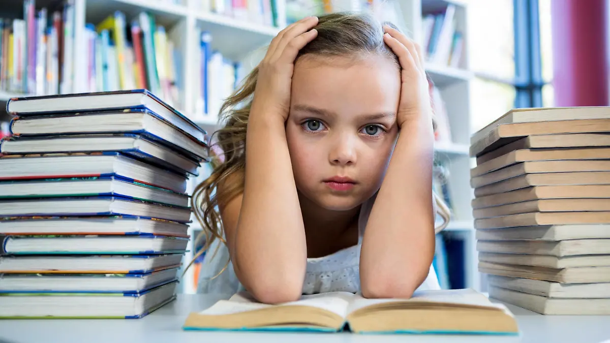 Stressed girl with books at table in school library Copyright: xWavebreakmediaMicrox Panthermedia20424533,model released, Symbolfoto ,property released