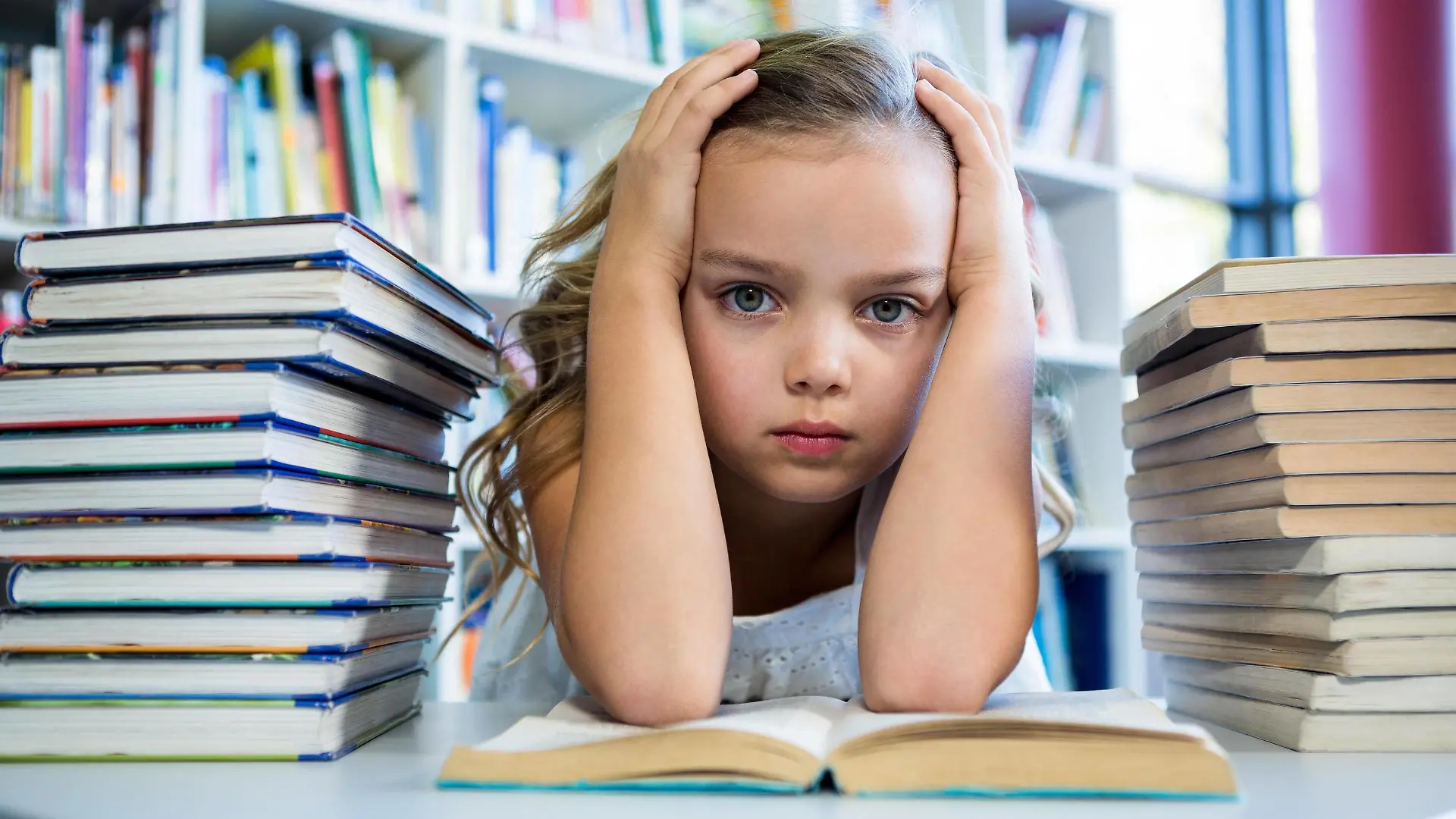 Stressed girl with books at table in school library Copyright: xWavebreakmediaMicrox Panthermedia20424533,model released, Symbolfoto ,property released