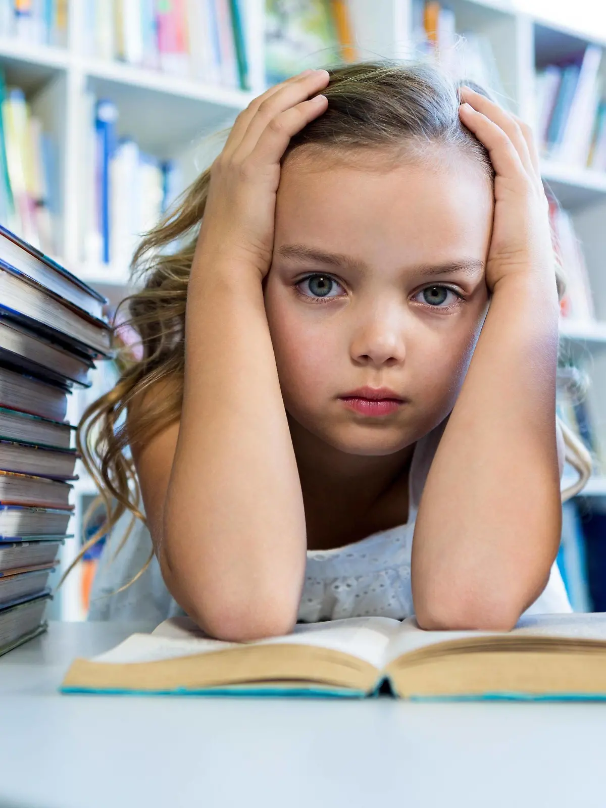 Stressed girl with books at table in school library Copyright: xWavebreakmediaMicrox Panthermedia20424533,model released, Symbolfoto ,property released