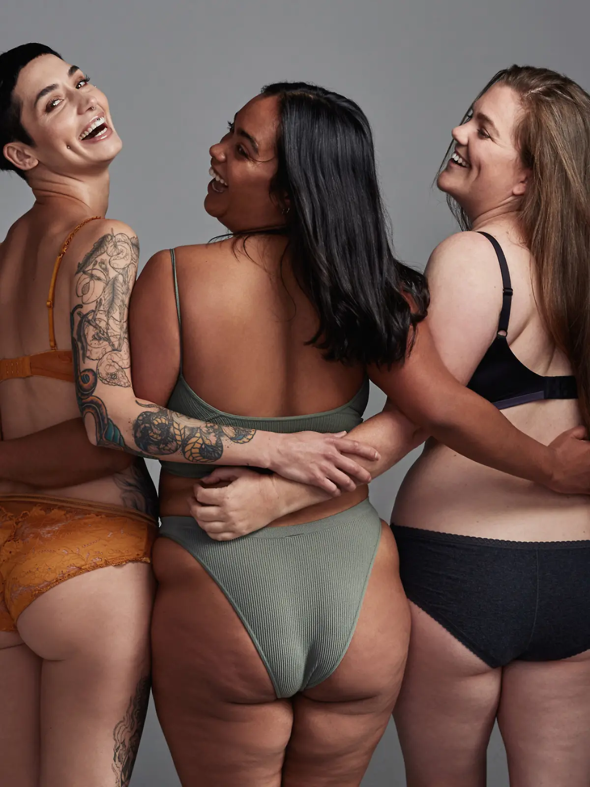 Drei Frauen mit verschiedenen Figuren lachen gemeinsam