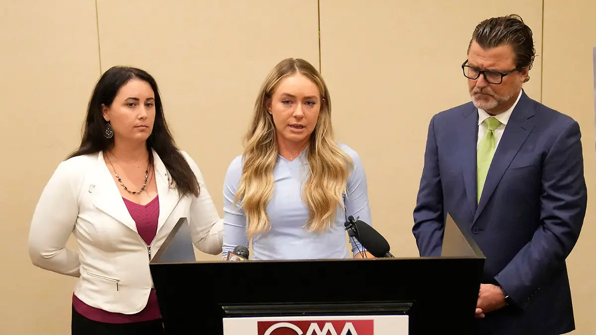 Tennis player Kylie McKenzie, middle, with her attorney Robert Allard, right, and victim advocate Jancy Thompson, left, speaks to reporters at a news conference in Phoenix Tuesday, March 29, 2022. McKenzie alleges in a lawsuit that the U.S. Tennis Association failed to protect her from a coach who she says sexually abused her when she was 19. The Associated Press generally doesn't name alleged sexual assault victims but McKenzie agreed to let her identity be known in coverage of her lawsuit. (Michael Chow/The Arizona Republic via AP)