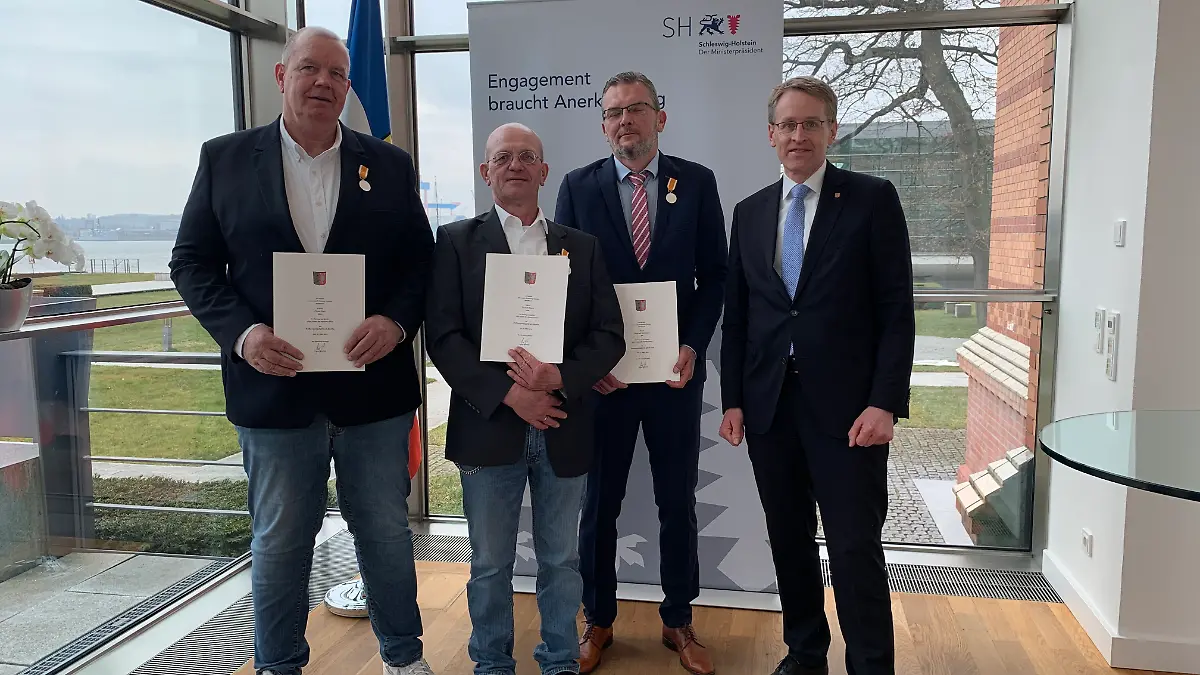 Oliver Gahl, Torsten Stern und Raphael Wiencierz werden von Ministerpräsident Daniel Günther geehrt.