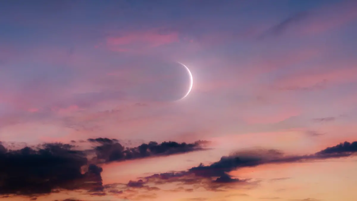 Ein Neumond beim Sonnenuntergang.