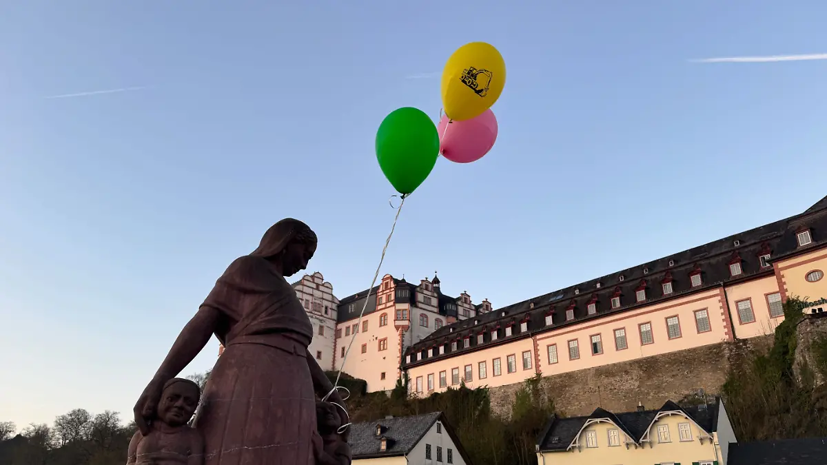 Bunte Luftballons hängen an einer Brücke über der Lahn, in der Hoffnung, die Aufmerksamkeit von Pawlos zu bekommen.