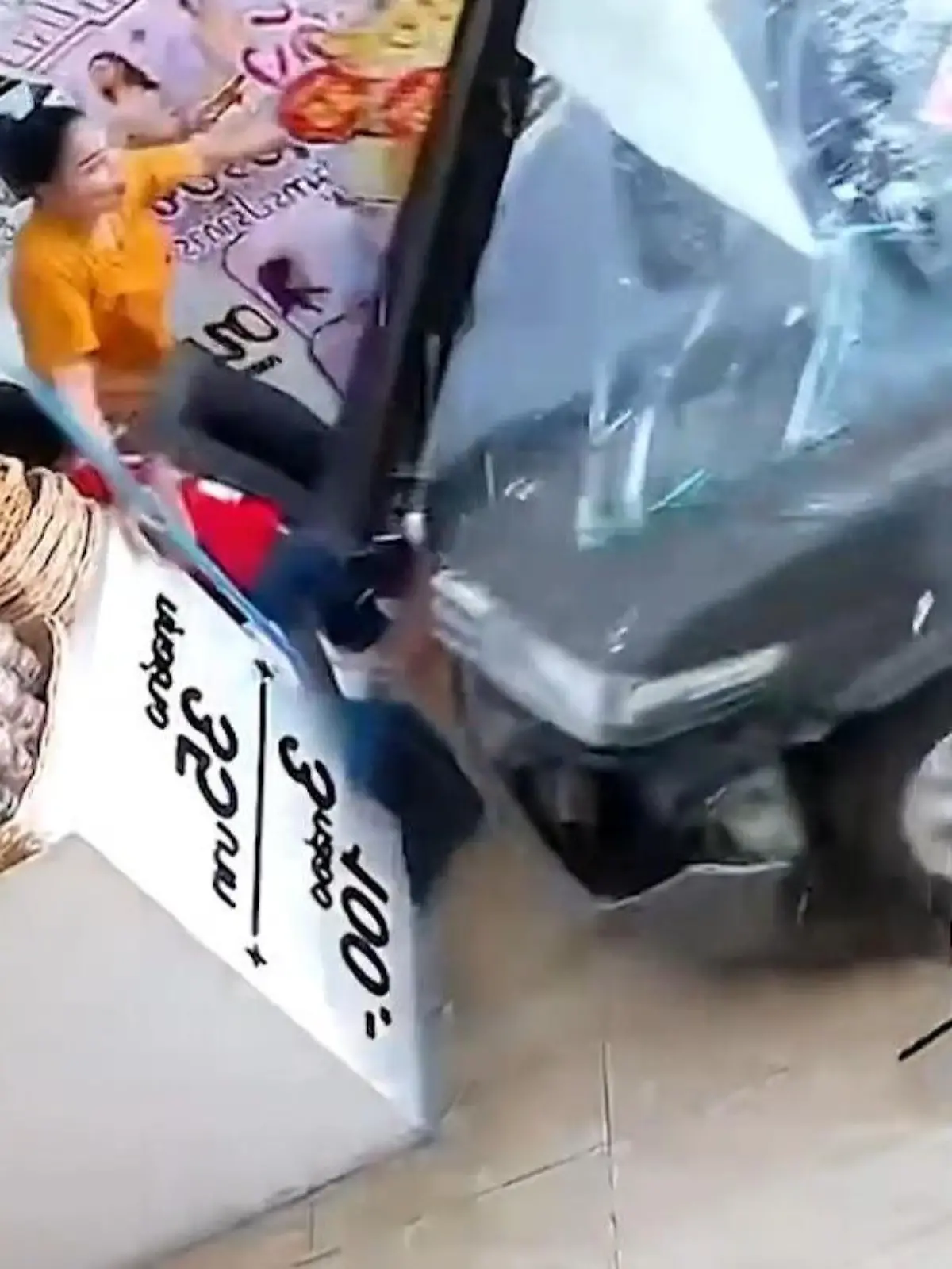 Eine Frau zerrt ihren Sohn gerade noch so weg, als ein Auto in das Geschäft rast