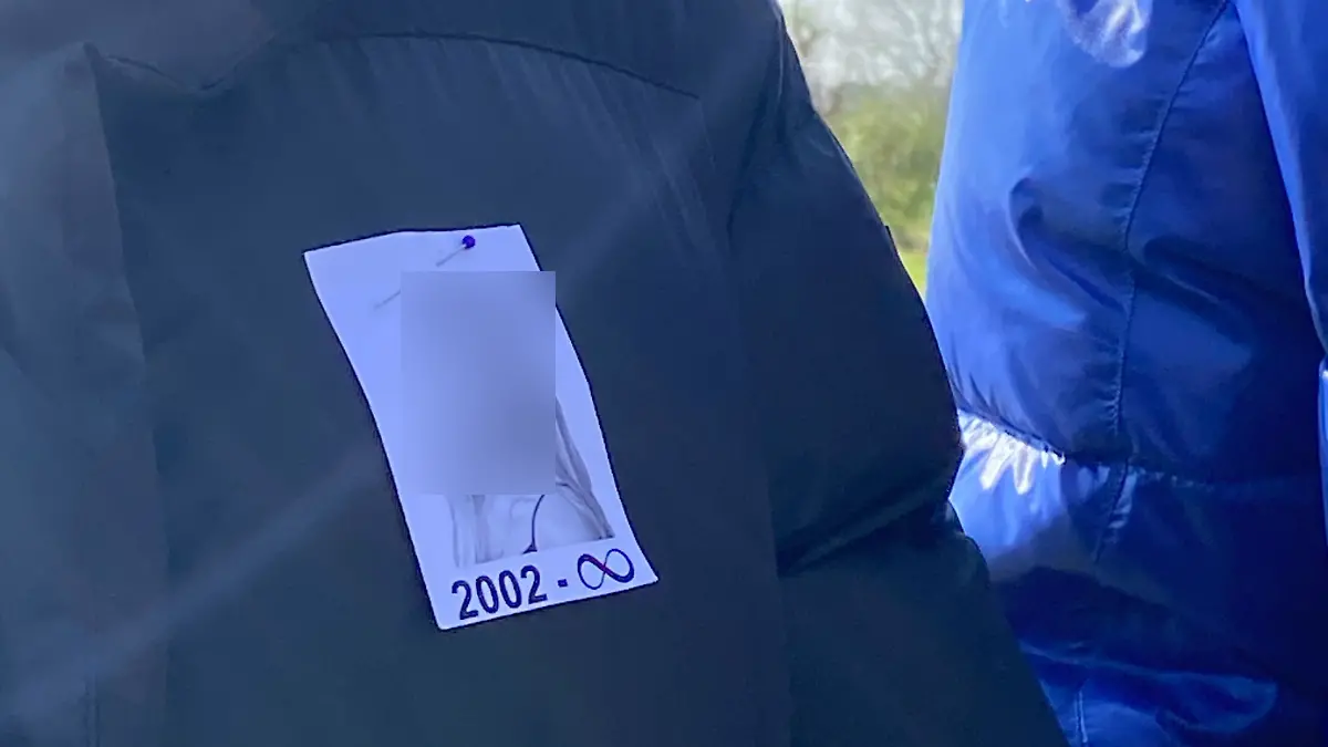Die Familie der verstorbenen Selin trägt ihr Bild an ihre Jacken gesteckt.