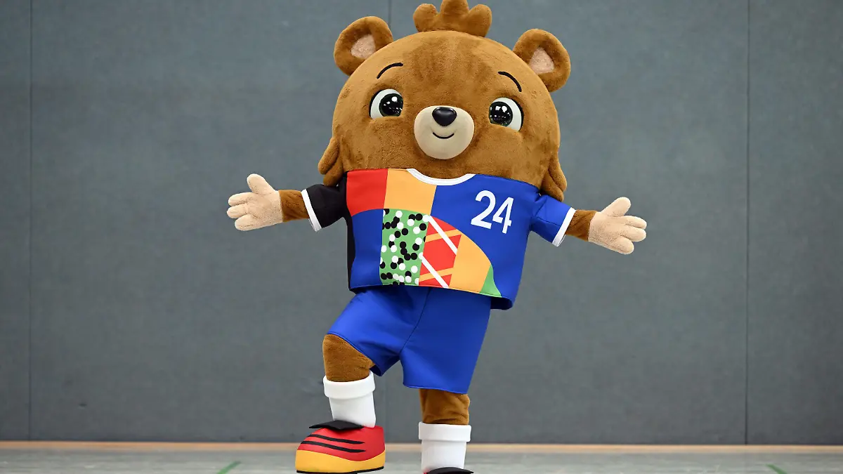 20.06.2023, Nordrhein-Westfalen, Gelsenkirchen: Fußball: EM 2024, Vorstellung des offiziellen Maskottchens. Das noch namenlose Maskottchen steht in einer Sporthalle. Ein putziger kleiner Bär - mit Hose. Die Europäische Fußball-Union UEFA hat am Dienstag das Maskottchen für die EM 2024 in Deutschland vorgestellt. Foto: Federico Gambarini/dpa +++ dpa-Bildfunk +++