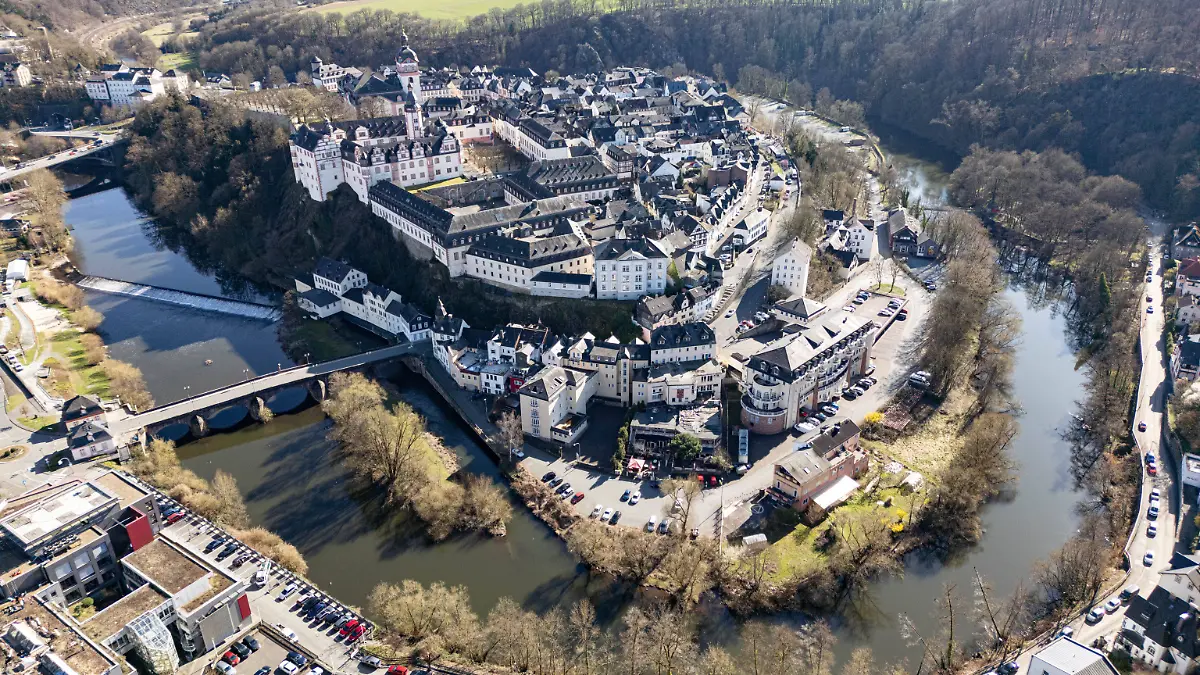 dpatopbilder - 27.03.2025, Hessen, Weilburg: Die Lahn schlängelt sich um die Innenstadt von Weilburg (Luftaufnahme mit einer Drohne). Unterdessen läuft die Suche nach dem vermissten sechsjährigen Jungen Pawlos weiter. Foto: Boris Roessler/dpa +++ dpa-Bildfunk +++