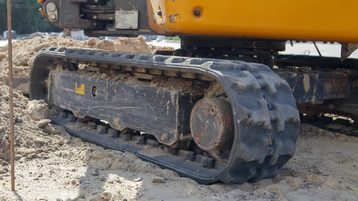 Zwei kleine Bagger auf einer Großbaustelle. Leuchtend grün auf Rädern und gelb auf Ketten. Erdarbeiten und Bauarbeiten. Schaufelbagger. Mini-Lader.