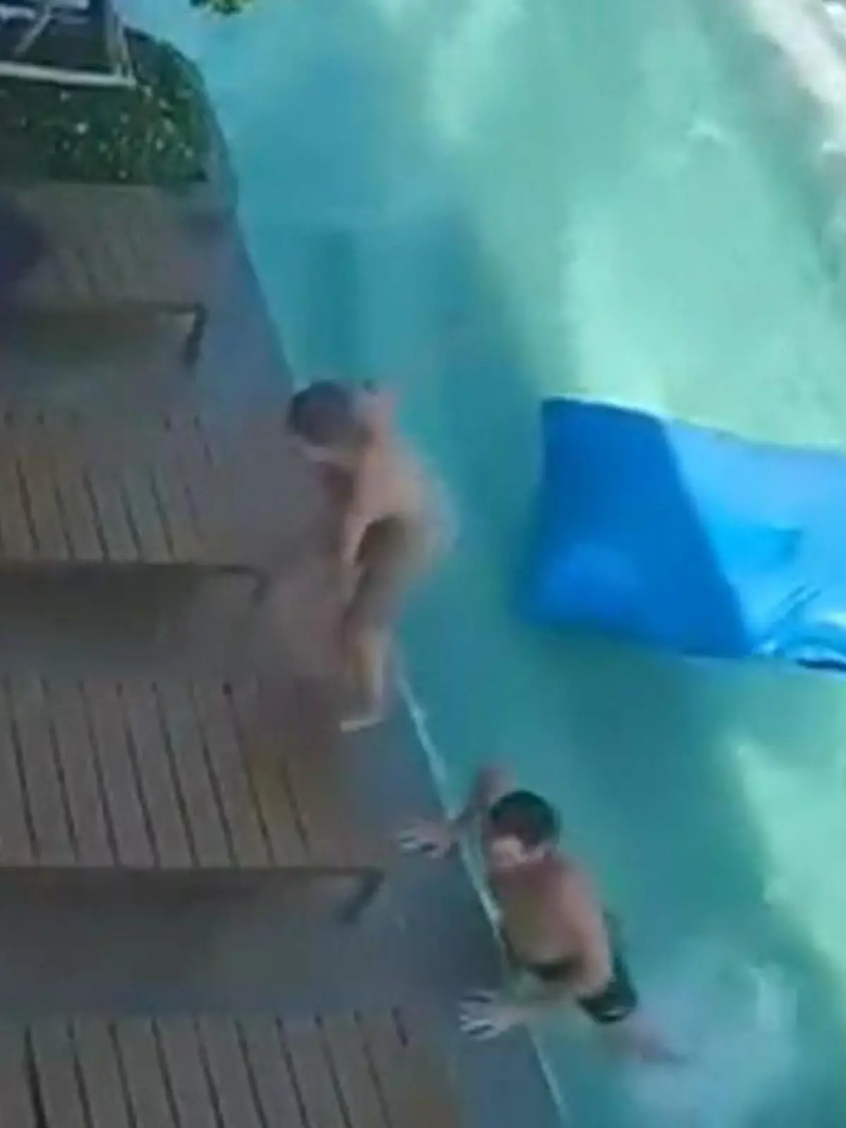Urlauber klettern gerade aus dem Pool, der wegen des Erdbebens hohe Wellen schlägt.
