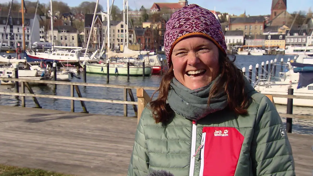 Eine Frau in Flensburg lacht herzlich.