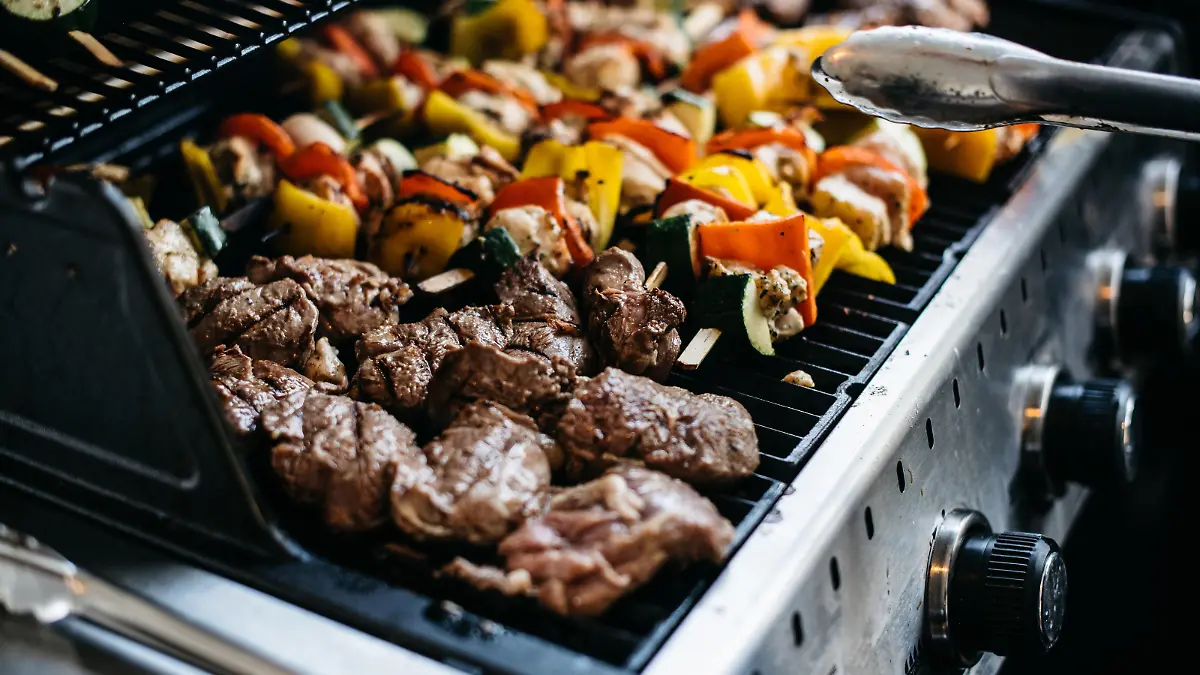 Barbecue with skewers of pork and vegetables like bell peppers and zucchini