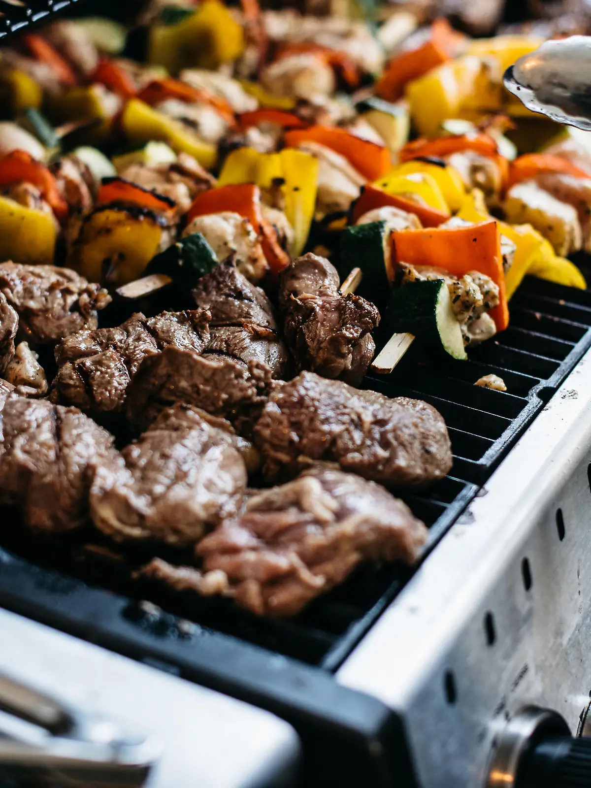 Barbecue with skewers of pork and vegetables like bell peppers and zucchini