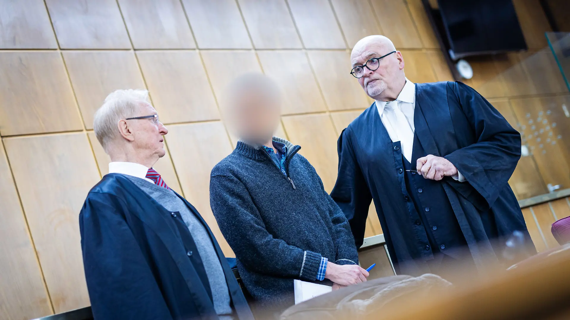 ARCHIV - 18.03.2025, Niedersachsen, Hannover: Der Angeklagte (M) steht im Gerichtssaal zwischen seinen Verteidigern Steffen Stern (l) und Matthias Waldraff (r). Das Landgericht hatte den Angeklagten aus Schleswig-Holstein wegen versuchten Mordes in Tateinheit mit gefährlicher Körperverletzung an seiner Mutter und wegen gefährlicher Körperverletzung an zwei seiner Orchesterkollegen zu einer Gesamtfreiheitsstrafe von sechs Jahren und sechs Monaten verurteilt. (zu dpa: «Geiger erhält für versuchten Giftmord längere Haftstrafe») Foto: Moritz Frankenberg/dpa +++ dpa-Bildfunk +++
