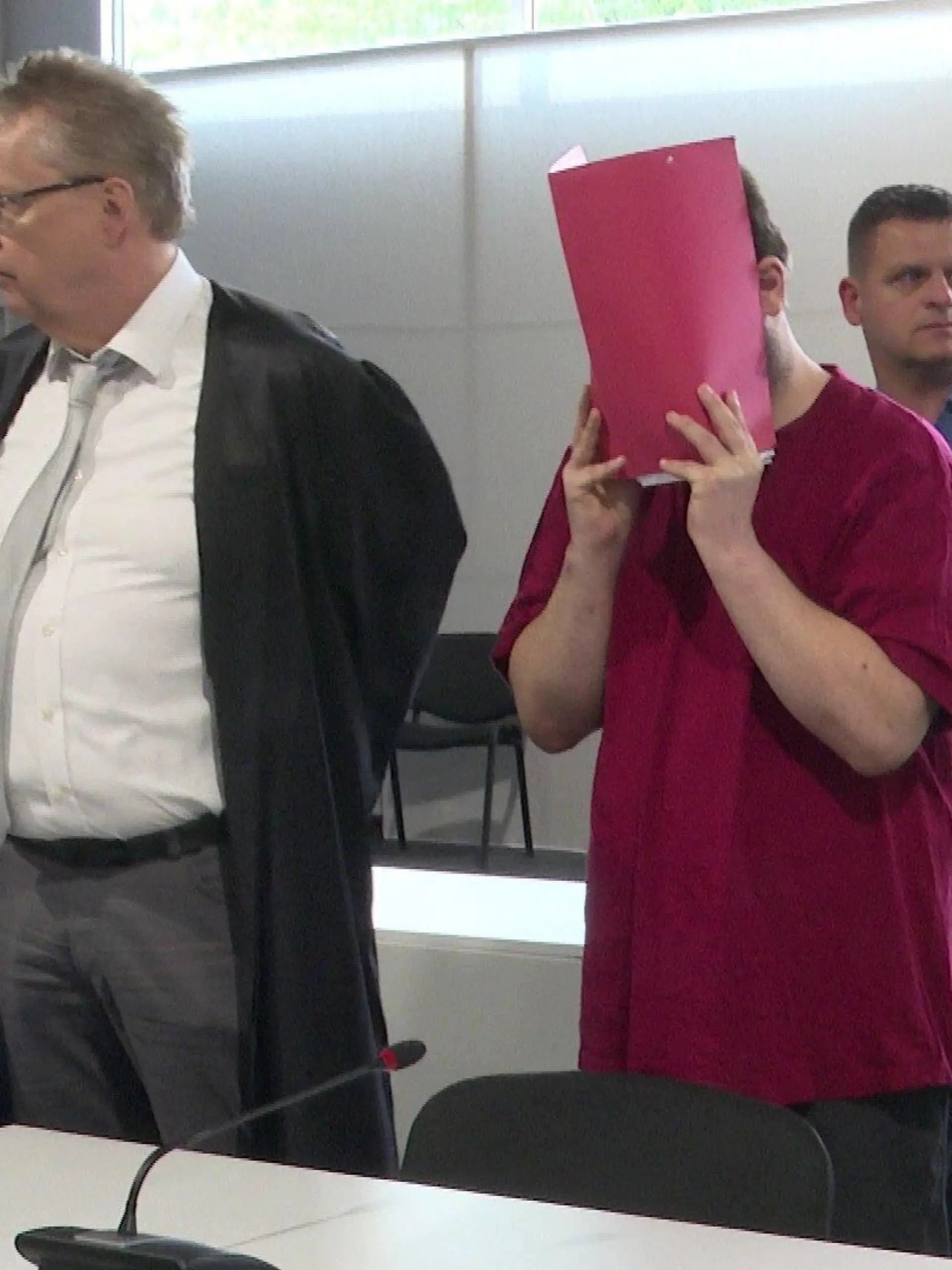 Jan Heiko P. hält sich im Gerichtssaal einen Ordner vor das Gesicht