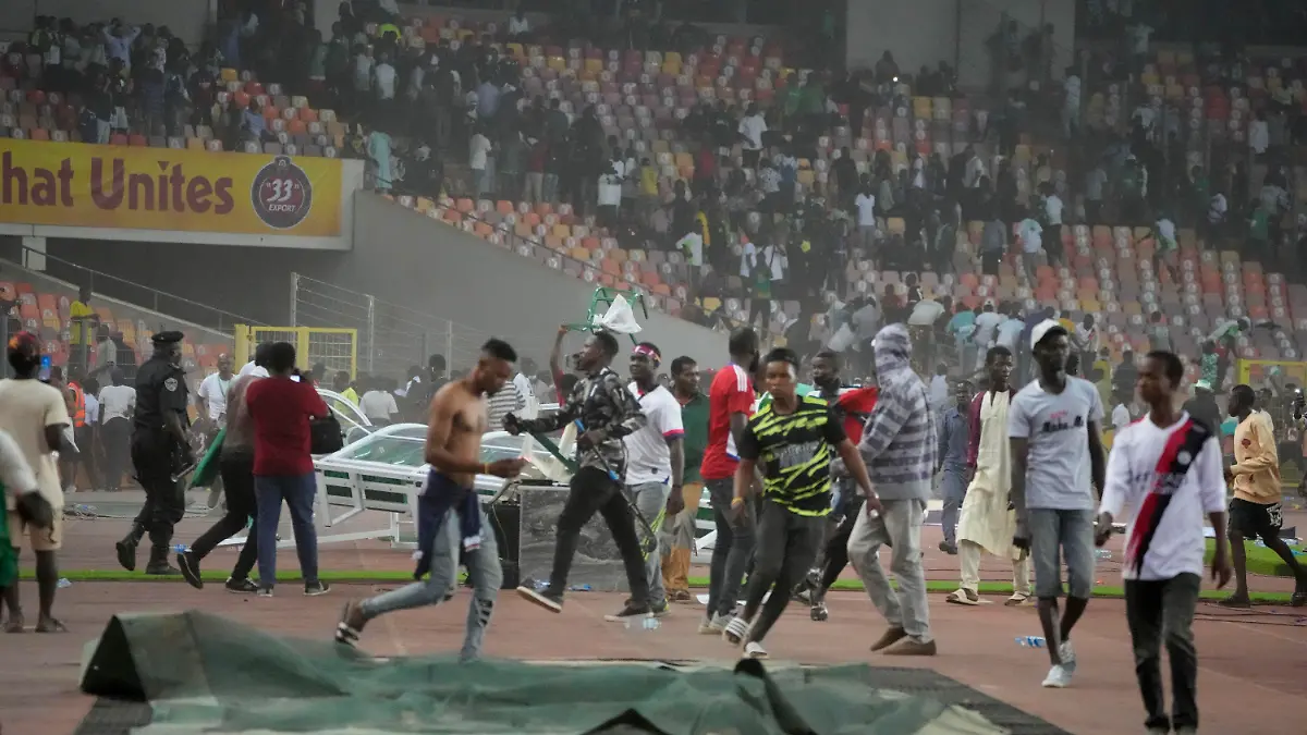 29.03.2022, Nigeria, Abuja: Fußball: WM-Qualifikation, Afrika, Nigeria - Ghana, M.K.O Abiola National Stadium Abuja: Die Polizei feuert Tränengas ab, um Fußball-Fans auseinanderzutreiben die das Spielfeld stürmten. Nach dem Aus der nigerianischen Fußball-Nationalmannschaft im entscheidenden WM-Qualifikationsspiel gegen Ghana ist es zu gewalttätigen Ausschreitungen gekommen. Foto: Sunday Alamba/AP/dpa +++ dpa-Bildfunk +++