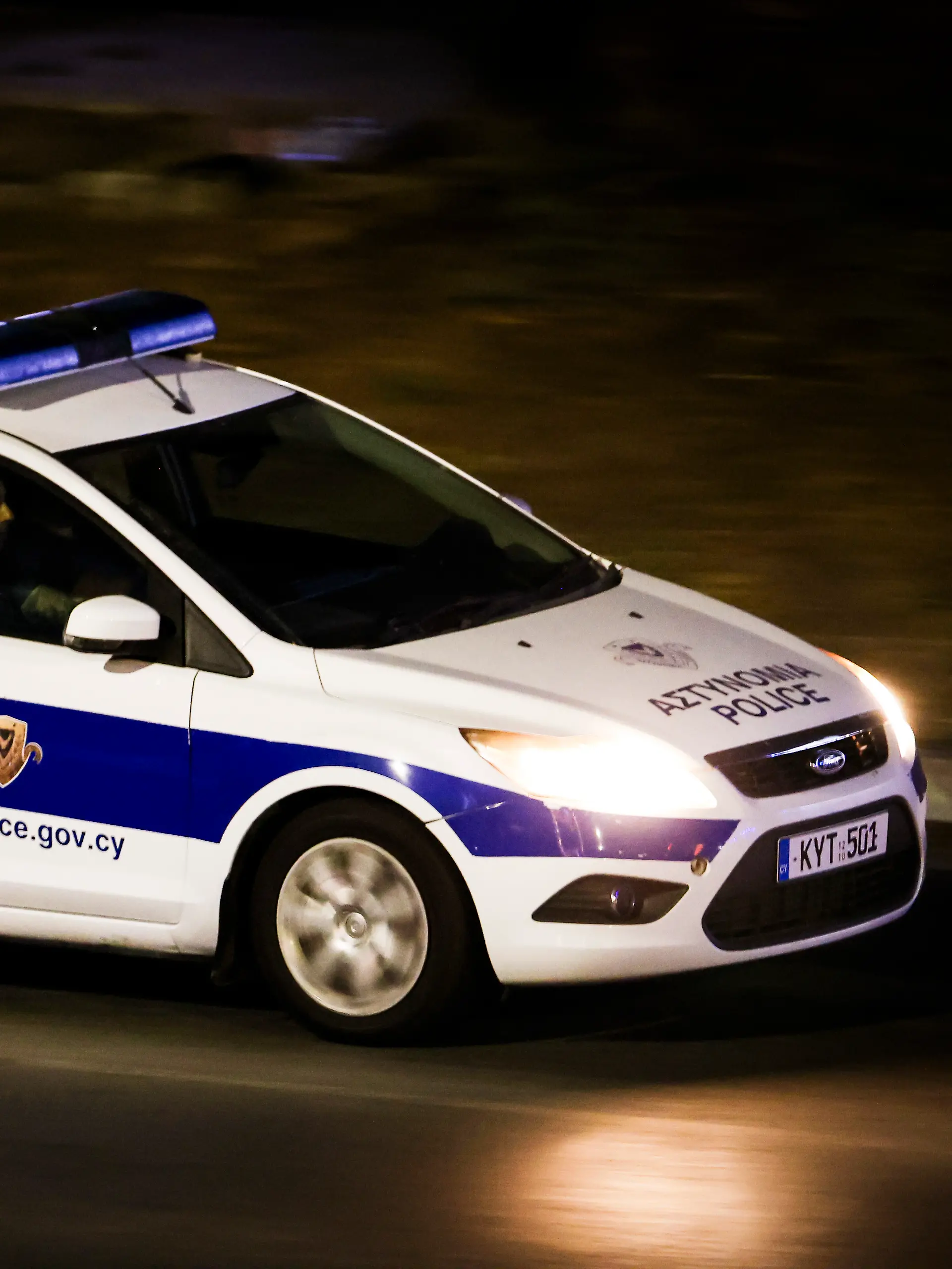Ein zypriotisches Polizeiauto fährt am Abend auf einer Straße in der Nähe zum Flughafen Larnaka.
