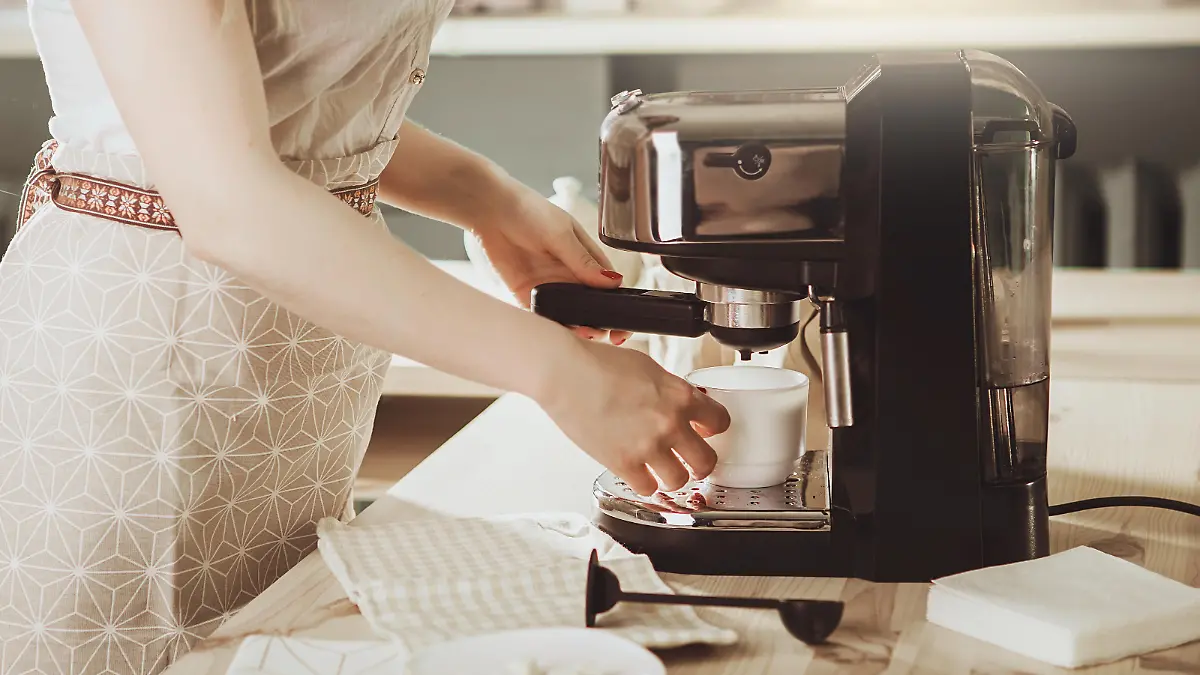 Woman making fresh espresso in coffee maker. coffee machine makes coffee. Barista Coffee Maker Machine Grinder Portafilter Concept