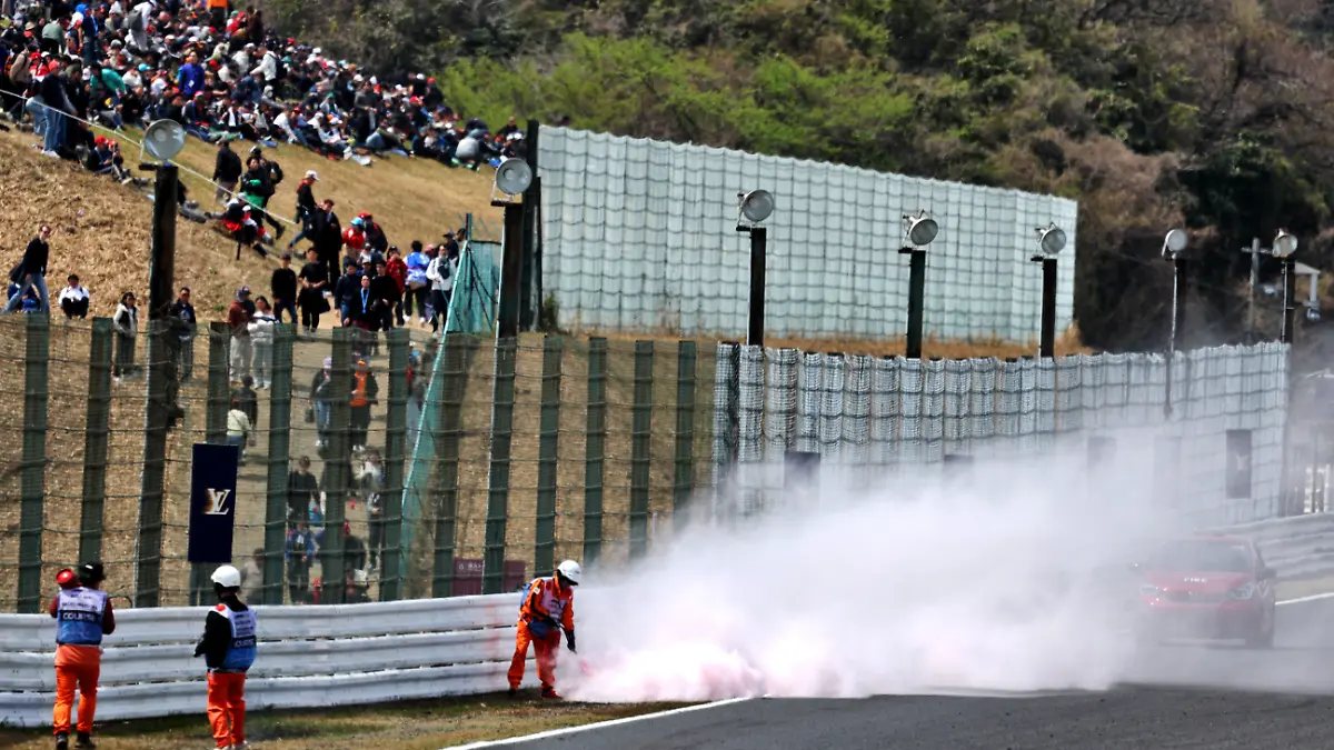 Streckenposten löschen ein Feuer im Gras neben der Strecke des Suzuka International Racing Course