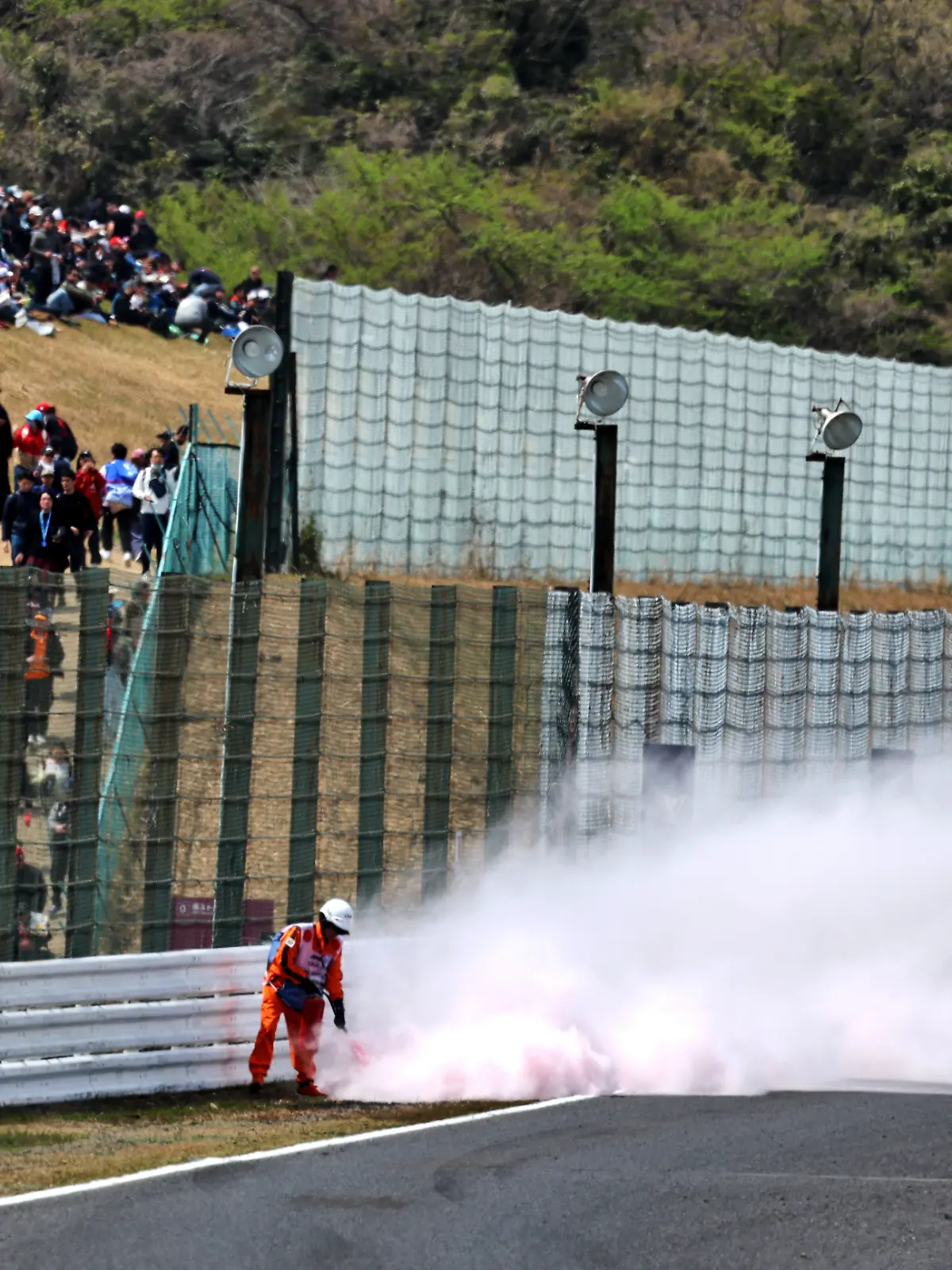 Streckenposten löschen ein Feuer im Gras neben der Strecke des Suzuka International Racing Course