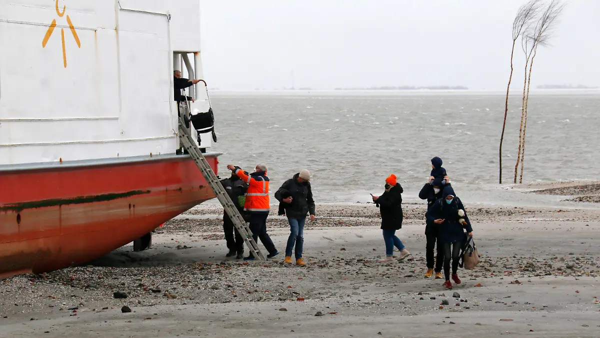 31.03.2022, Niedersachsen, Wangerooge: In der Hafeneinfahrt der Nordsee-Insel Wangerooge ist am Donnerstag eine Fähre auf Grund gelaufen. Es gebe keine Verletzten unter den Passagieren an Bord, sagte ein Sprecher der Deutschen Bahn (DB), die die Fähre betreibt. Alle 95 Passagiere konnten mit Hilfe der Besatzung an Land gebracht werden, wie das Wasser- und Schifffahrtsamt Wilhelmshaven am Abend mitteilte. Foto: Peter Kuchenbuch-Hanken/dpa +++ dpa-Bildfunk +++