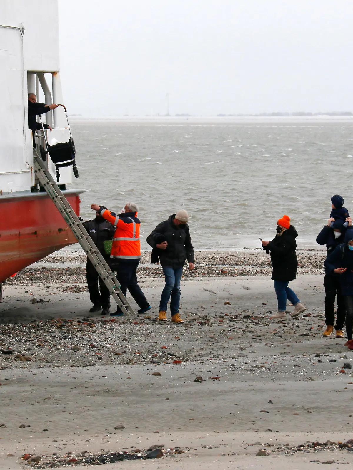 31.03.2022, Niedersachsen, Wangerooge: In der Hafeneinfahrt der Nordsee-Insel Wangerooge ist am Donnerstag eine Fähre auf Grund gelaufen. Es gebe keine Verletzten unter den Passagieren an Bord, sagte ein Sprecher der Deutschen Bahn (DB), die die Fähre betreibt. Alle 95 Passagiere konnten mit Hilfe der Besatzung an Land gebracht werden, wie das Wasser- und Schifffahrtsamt Wilhelmshaven am Abend mitteilte. Foto: Peter Kuchenbuch-Hanken/dpa +++ dpa-Bildfunk +++