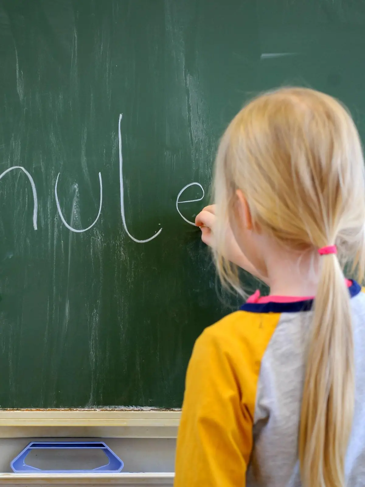  Ein Schulkind schreibt mit Kreide an eine Schultafel den Satz Schule ist schön , aufgenommen am 19.01.2015 in Dresden.
