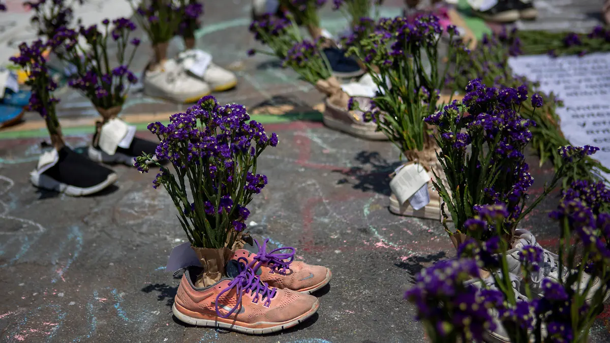 Pairs of shoes with bouquets of flowers inside represent gender violence during a demonstration marking International Women's Day in downtown Guatemala City, Tuesday, March 8, 2022. (AP Photo/Oliver de Ros)
