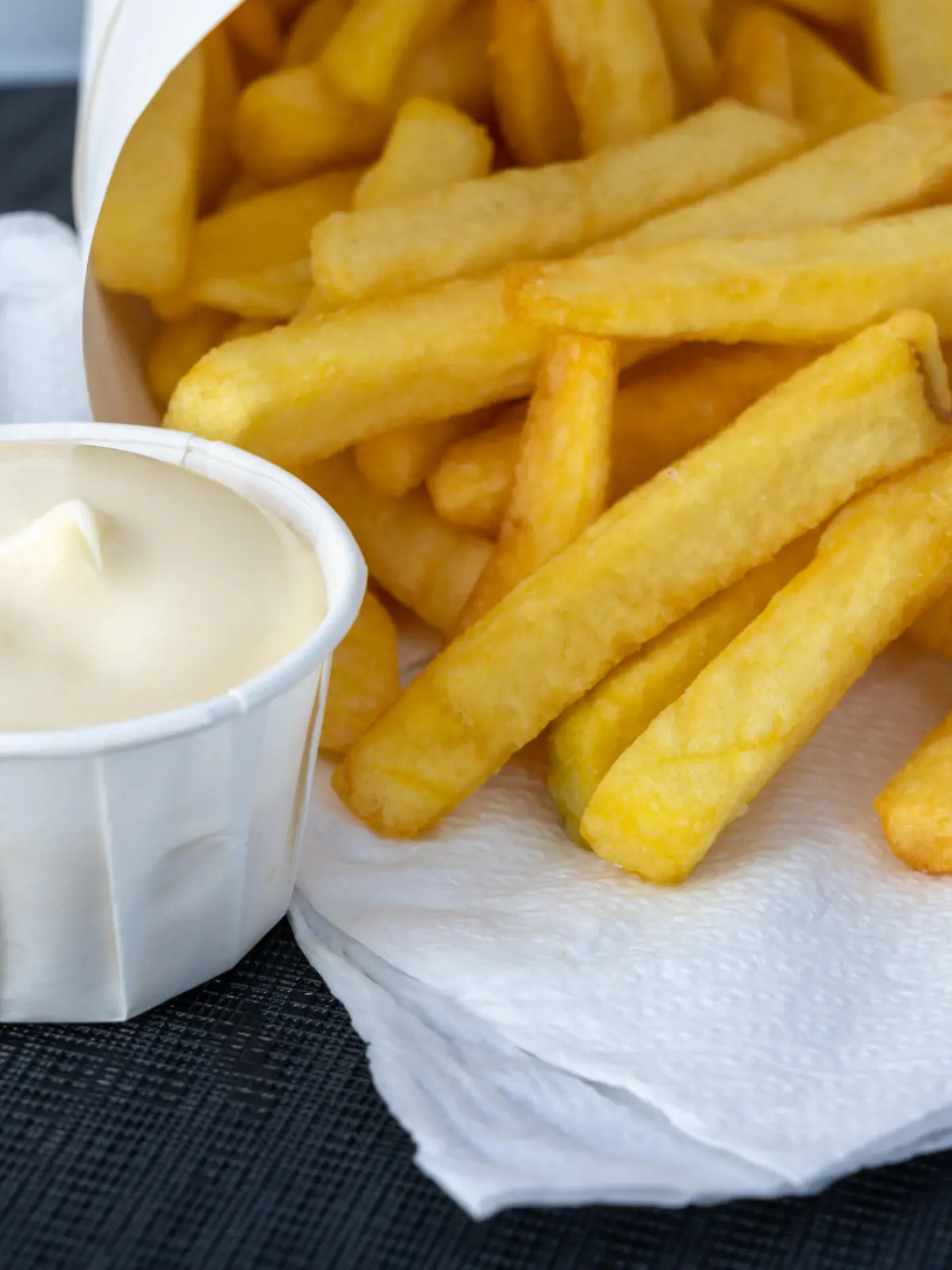 Eating of street or take away food fresh baked french fried potatoes chips in paper cone