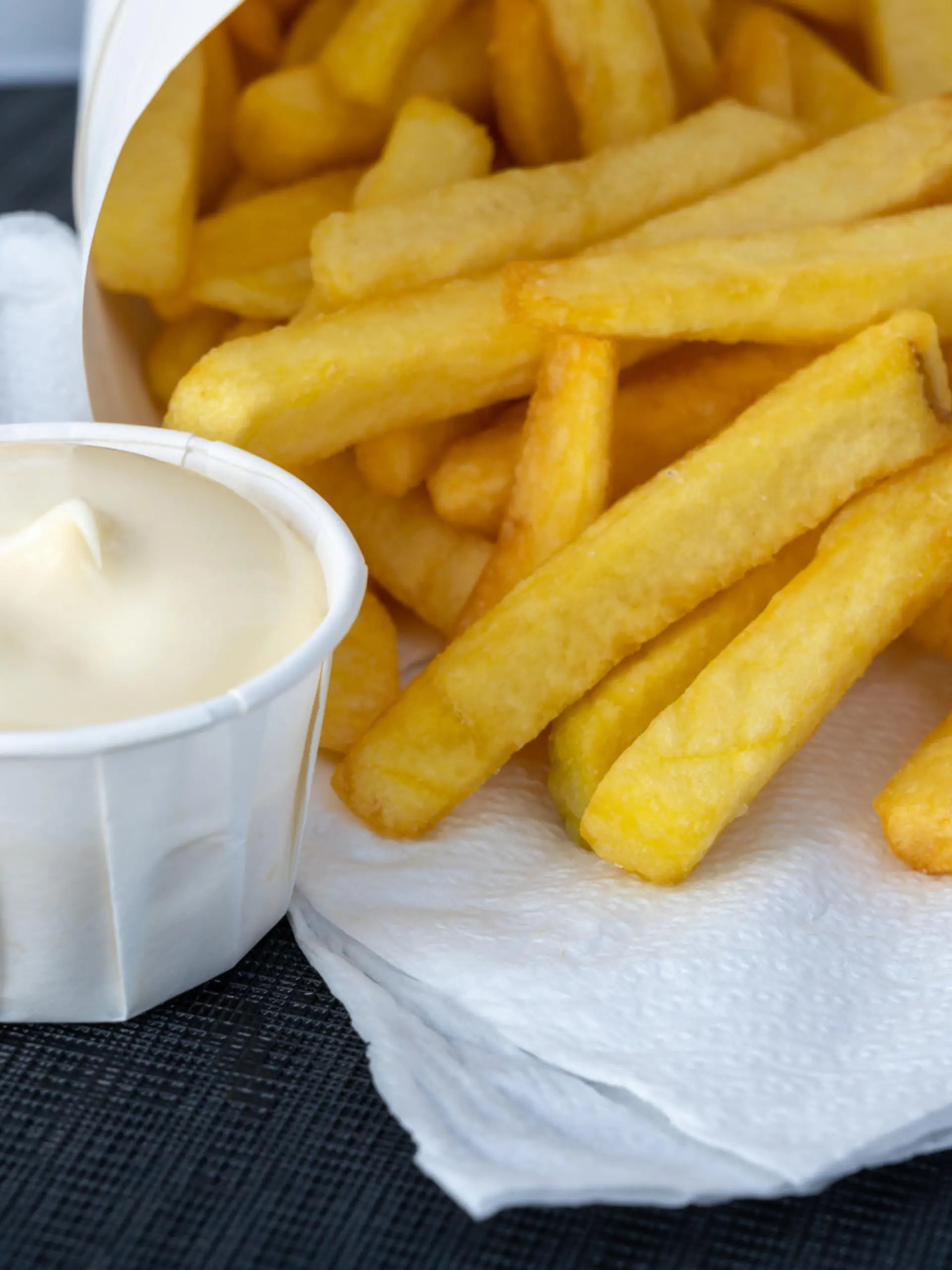 Eating of street or take away food fresh baked french fried potatoes chips in paper cone